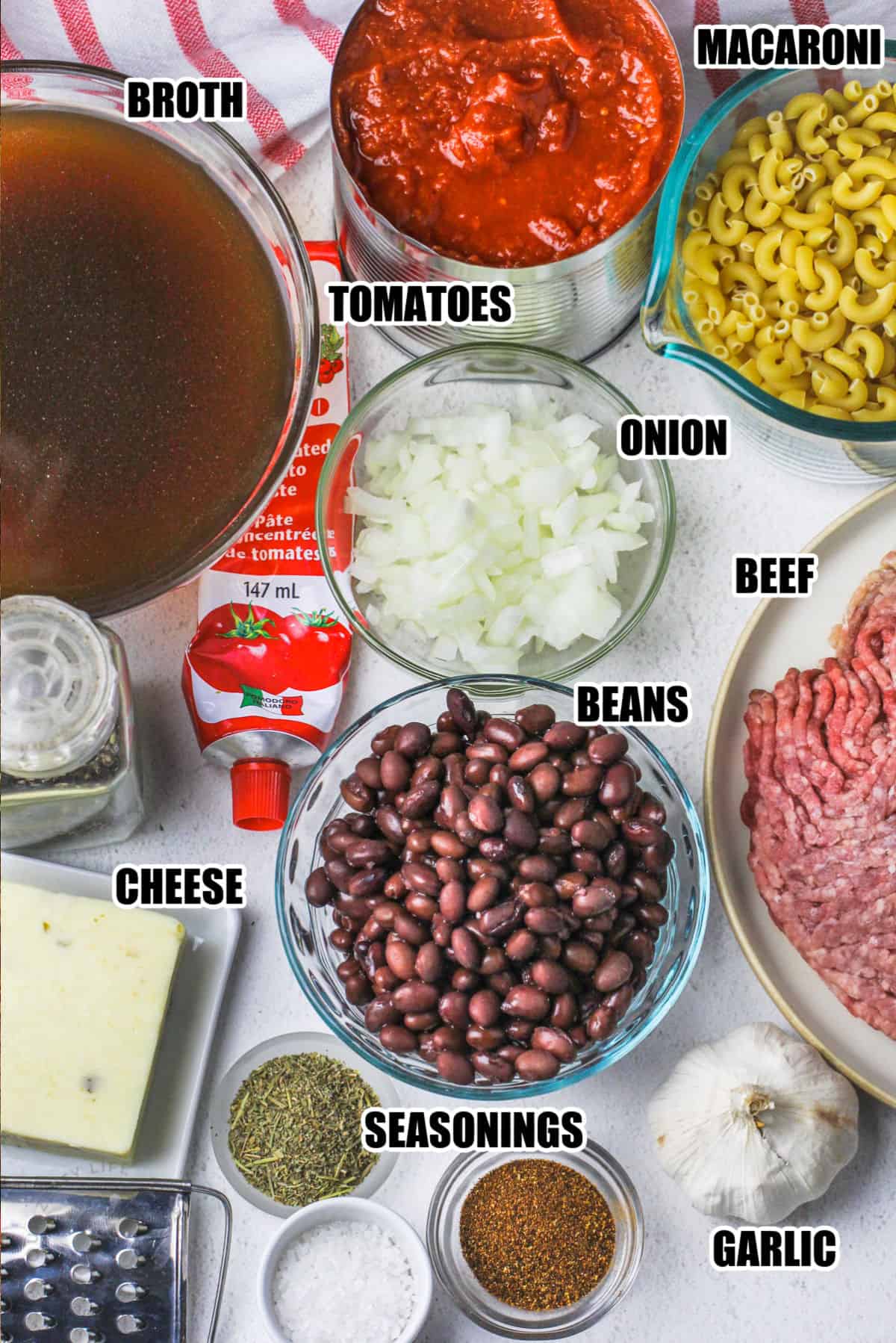 broth , tomatoes , macaroni , onion , beef , beans , cheese, garlic and seasonings to make Chili Mac Recipe with labels
