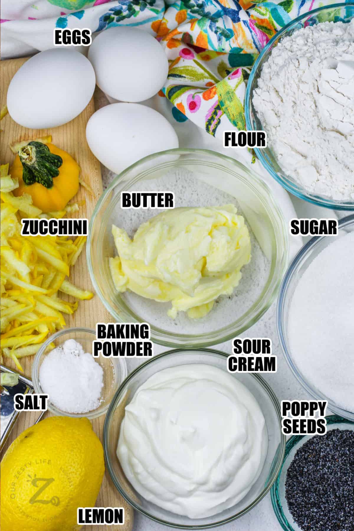 eggs , flour , butter , sugar , zucchini , baking powder , sour cream , salt , lemon and poppy seeds with labels to make Lemon Zucchini Bread
