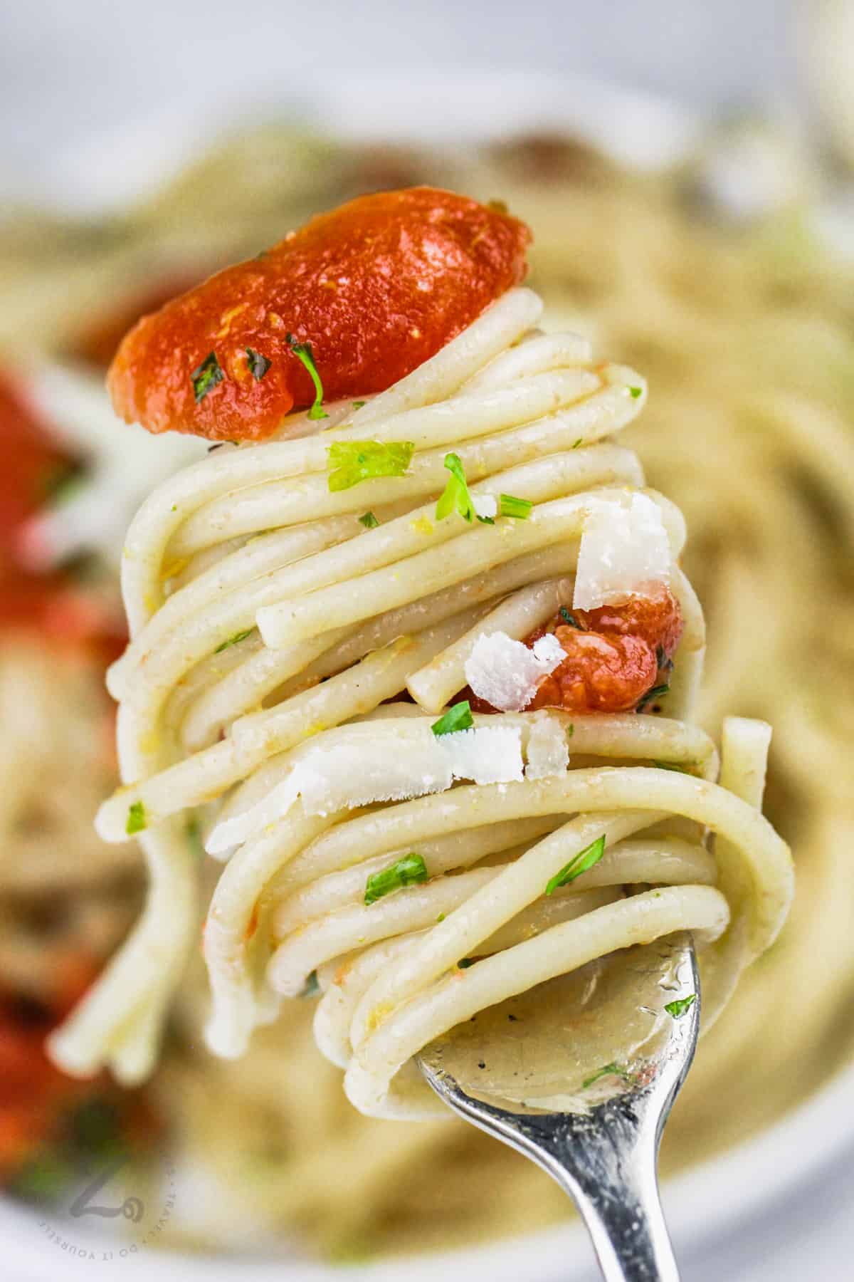 simple lemon tomato pasta twirled on a fork
