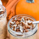 Pumpkin Overnight Oats in jars with walnuts on top