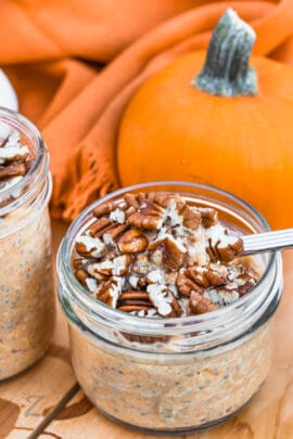 Pumpkin Overnight Oats in jars with walnuts on top