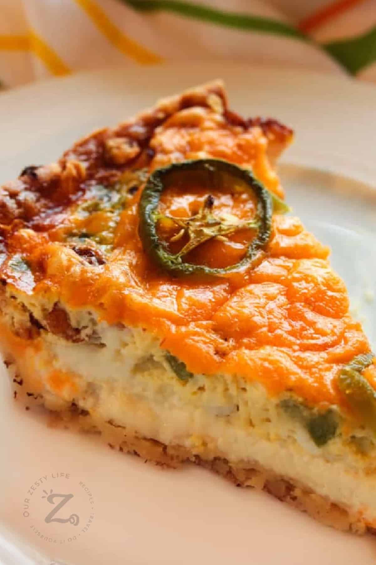 close up of bacon and cheese quiche with a jalapeno slice on top