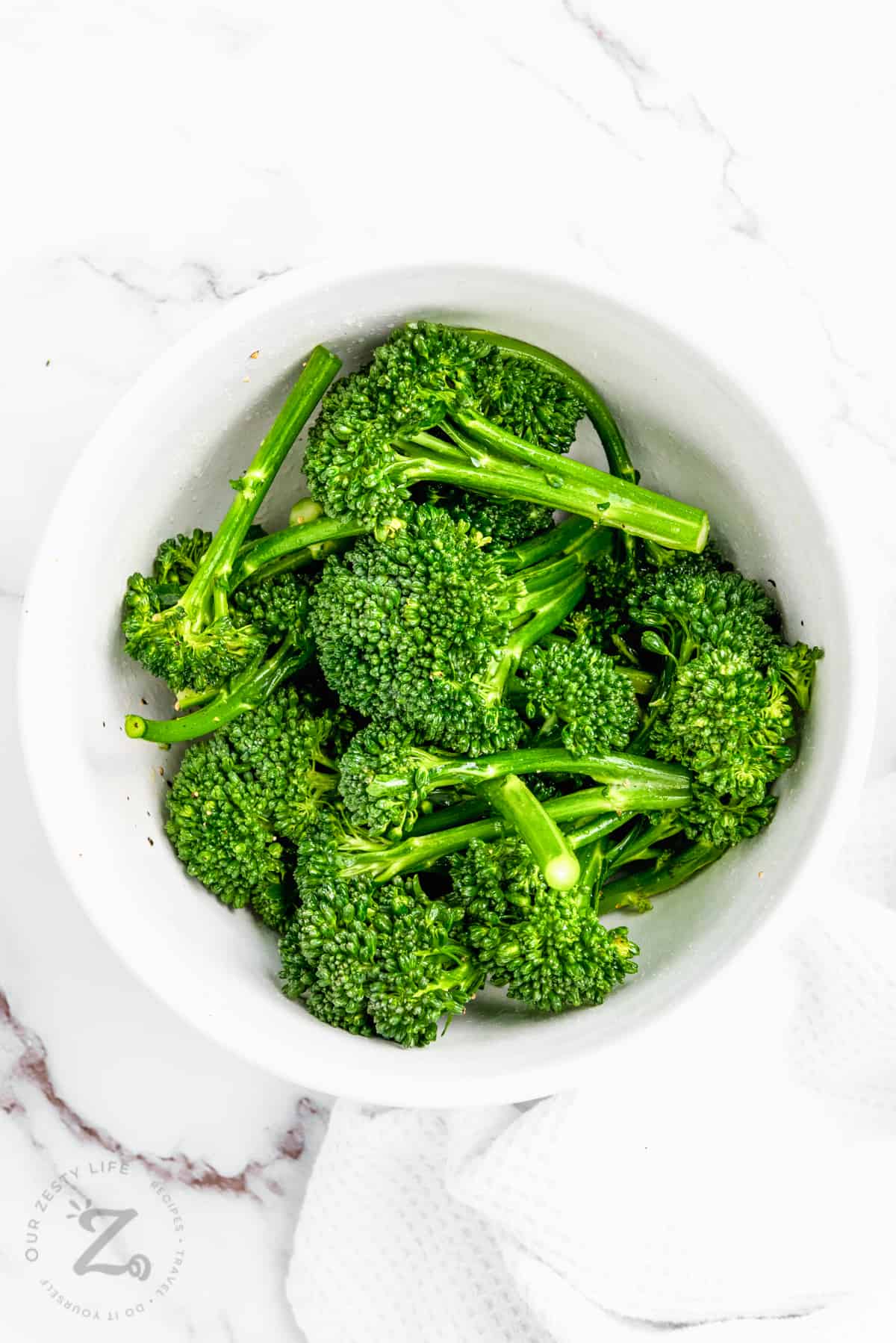 broccolini in a bowl with oil salt and pepper to make Air Fryer Broccolini