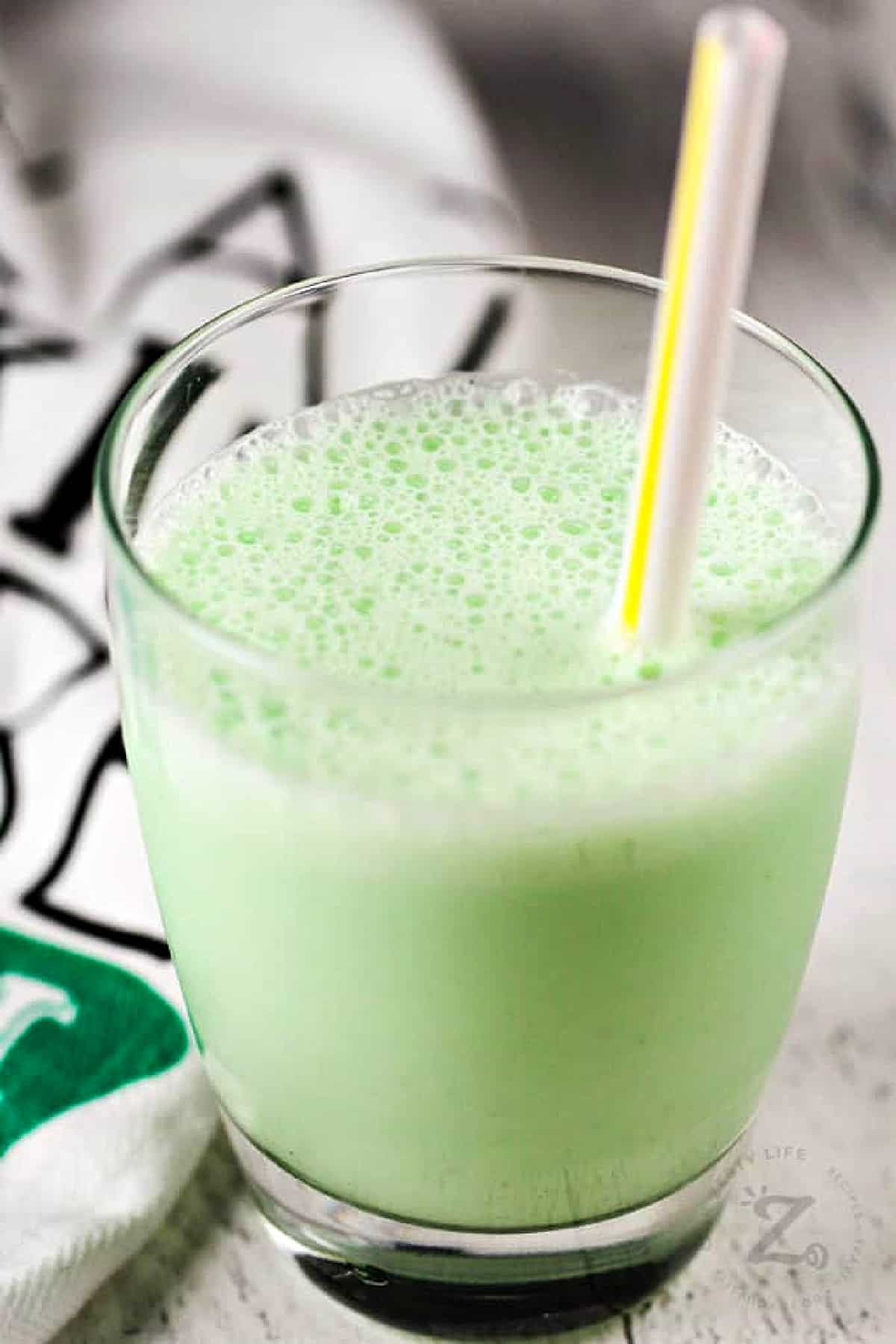close up of copycat shamrock shake in a clear glass with a straw