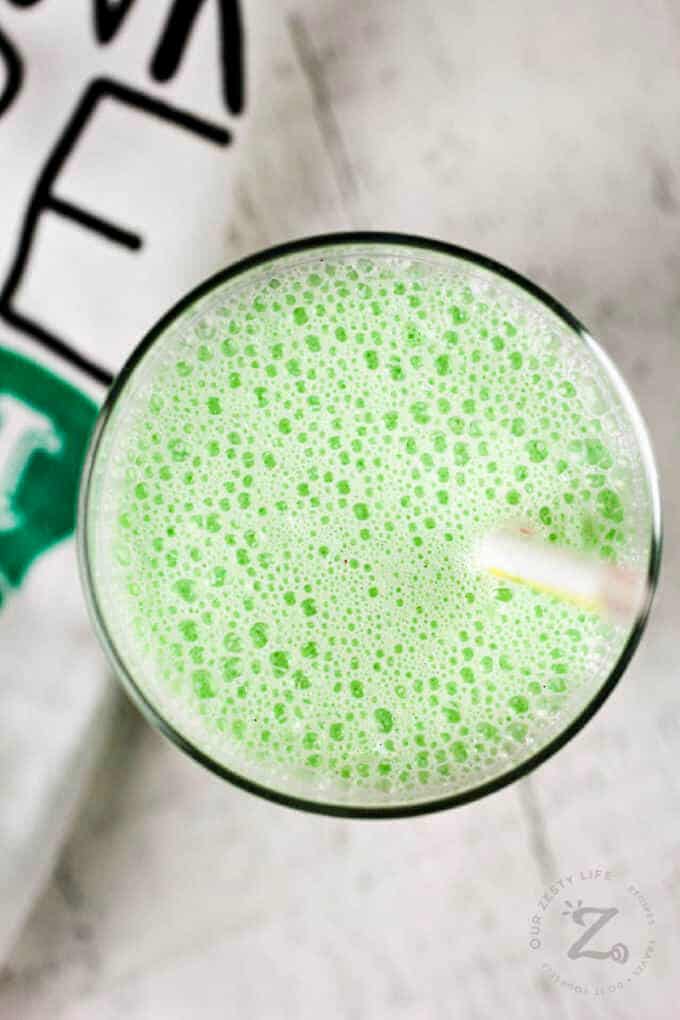 close up of copycat shamrock shake in a clear glass with a straw, and a towel beside it