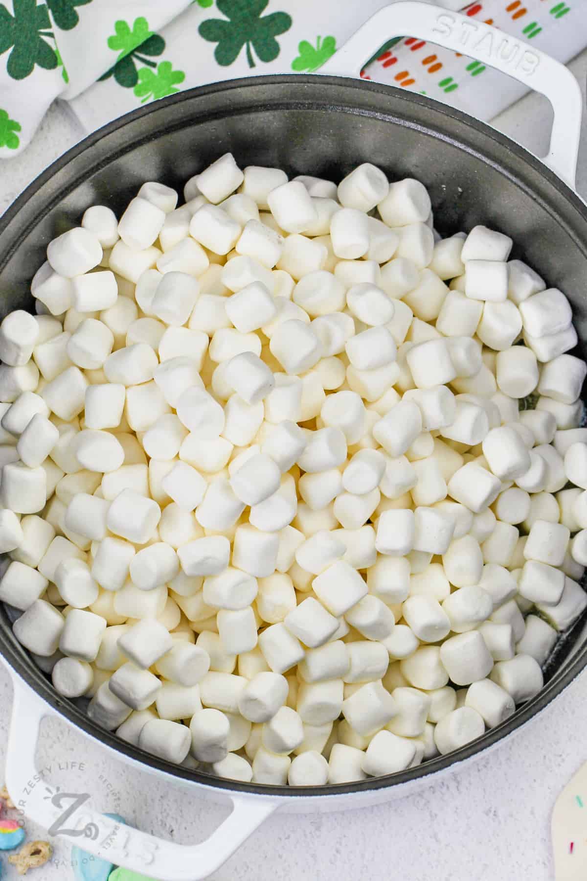 adding marshmallows to pot to make Lucky Charms Marshmallow Treats Squares