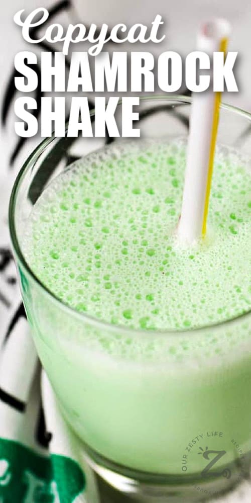 copycat shamrock shake in a clear glass with a straw, with writing