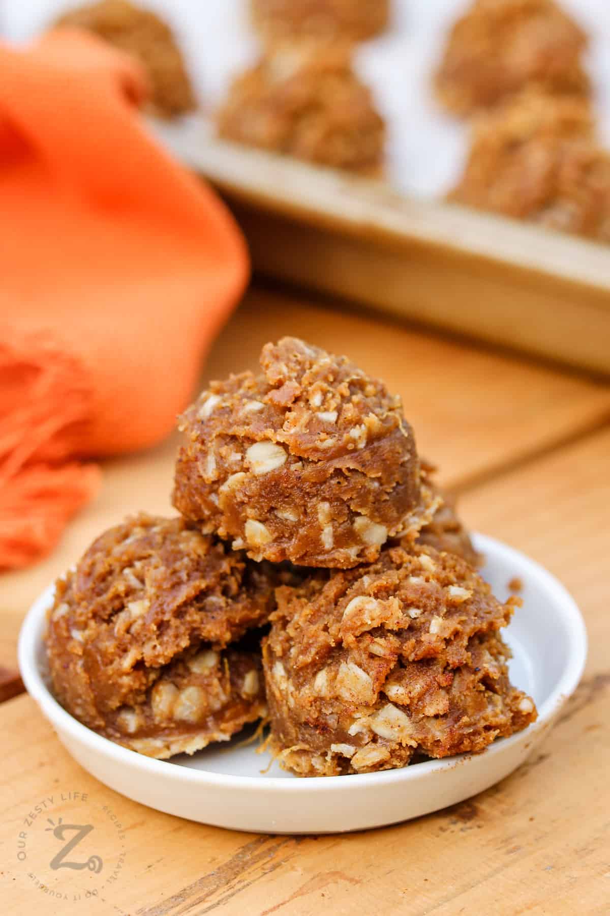 Pumpkin Energy Balls Recipe on a plate and with a sheet pan full in the back