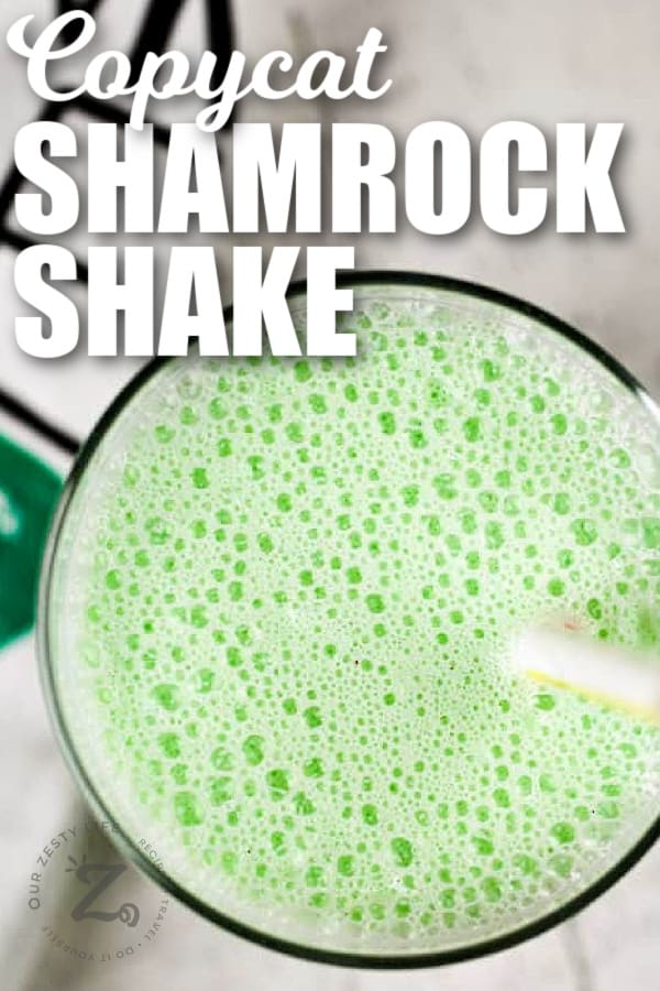 copycat shamrock shake in a clear glass with a straw and a towel beside it, with a title