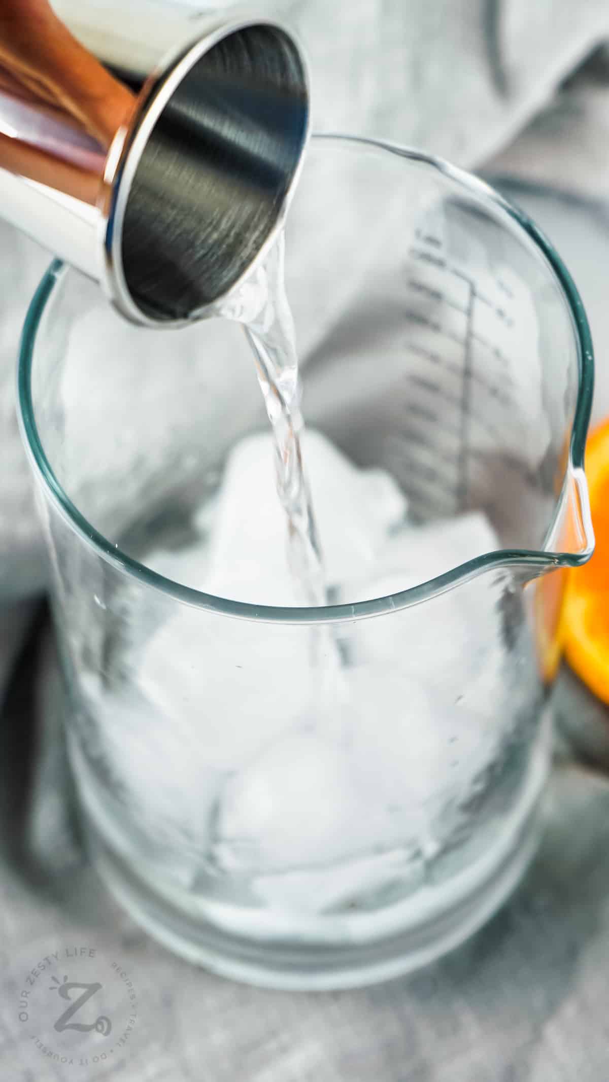 pouring liquids with ice to make Traditional Gin Martini