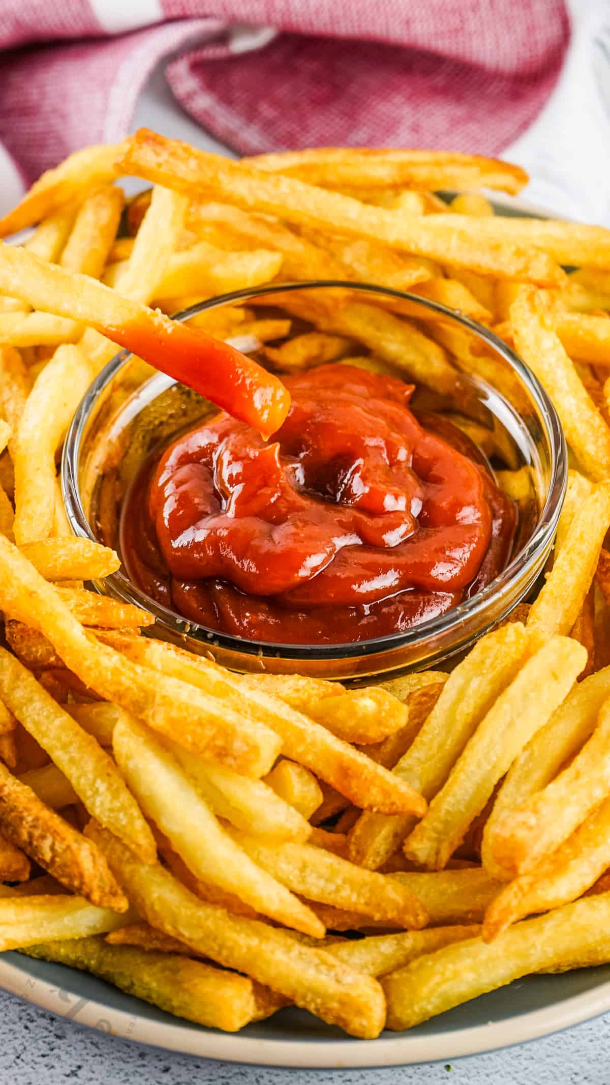 dipping Air Fryer Frozen French Fries in ketchup