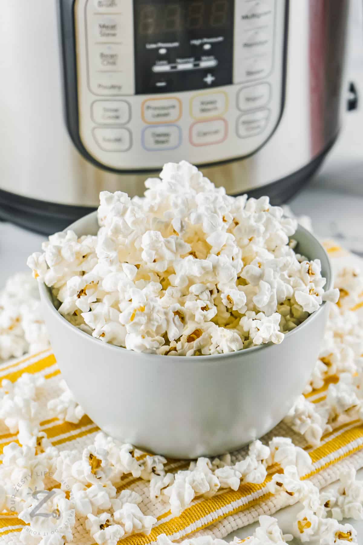bowl of Instant Pot Popcorn with instant pot in back