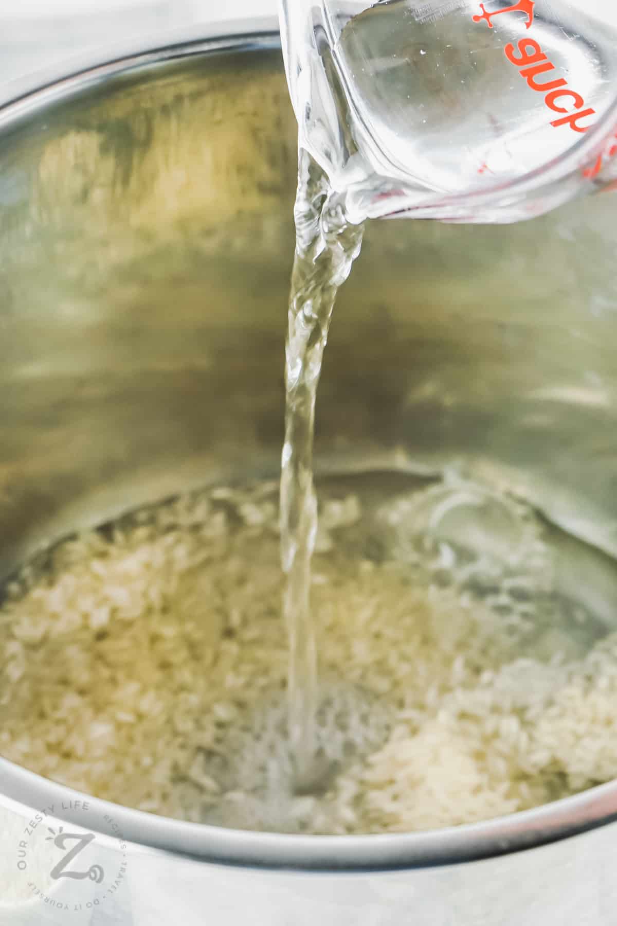 pouring water with rice to make Instant Pot Rice