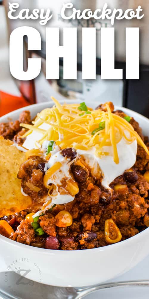bowl of Easy Crockpot Black Bean Chili with sour cream and cheese with writing