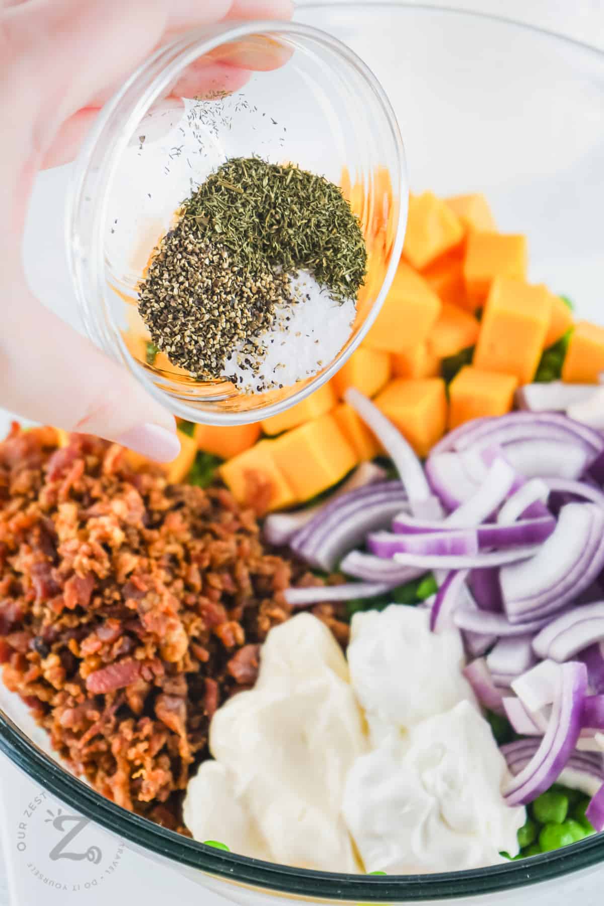 adding seasonings to ingredients to make Pea Salad