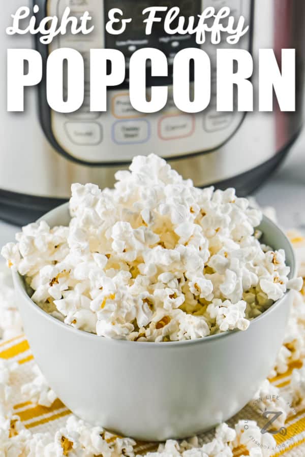 bowl of Instant Pot Popcorn with pot in the background and a title