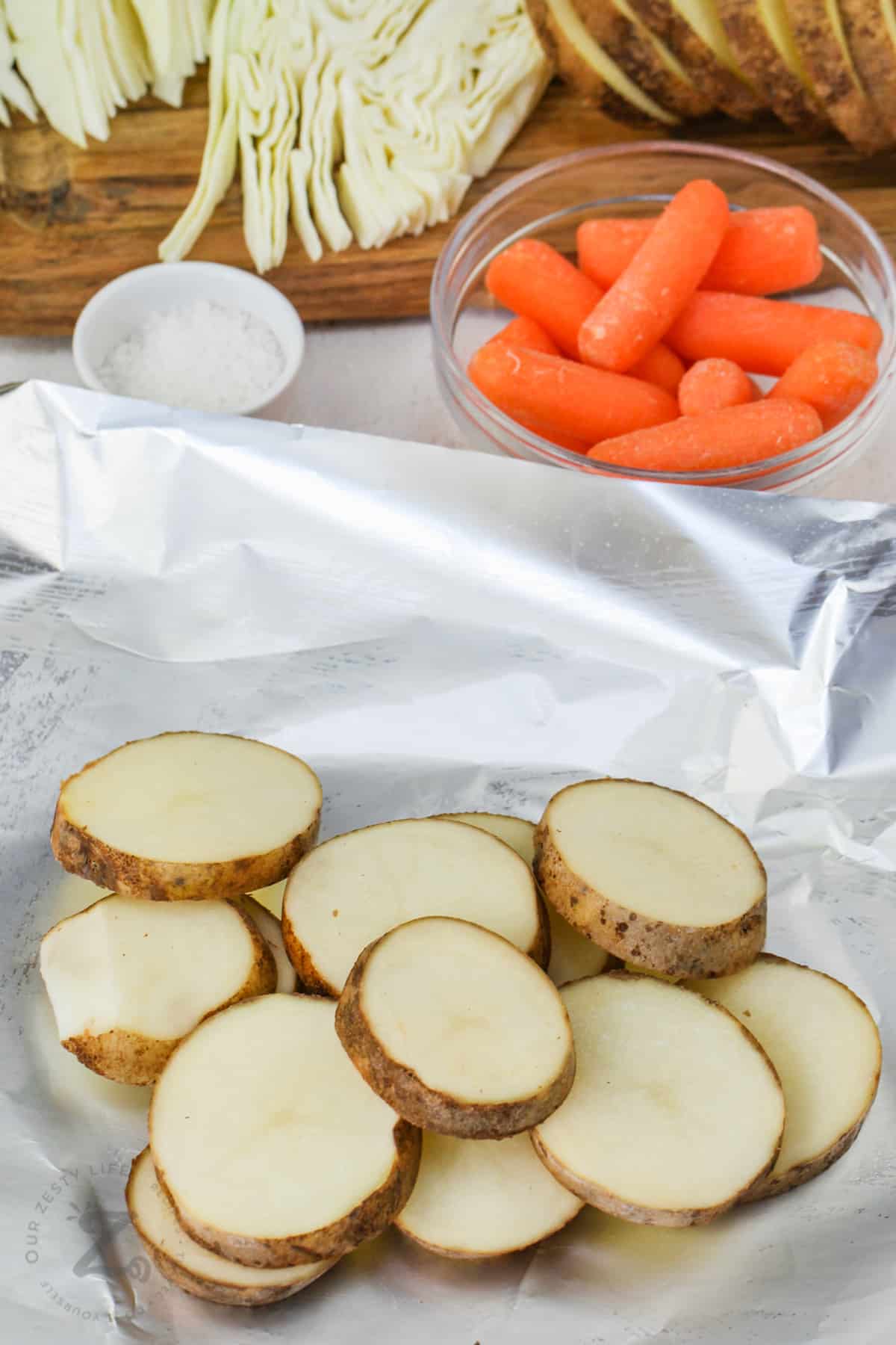 sliced potatoes in tin foil to make Cabbage and Potato Foil Packs