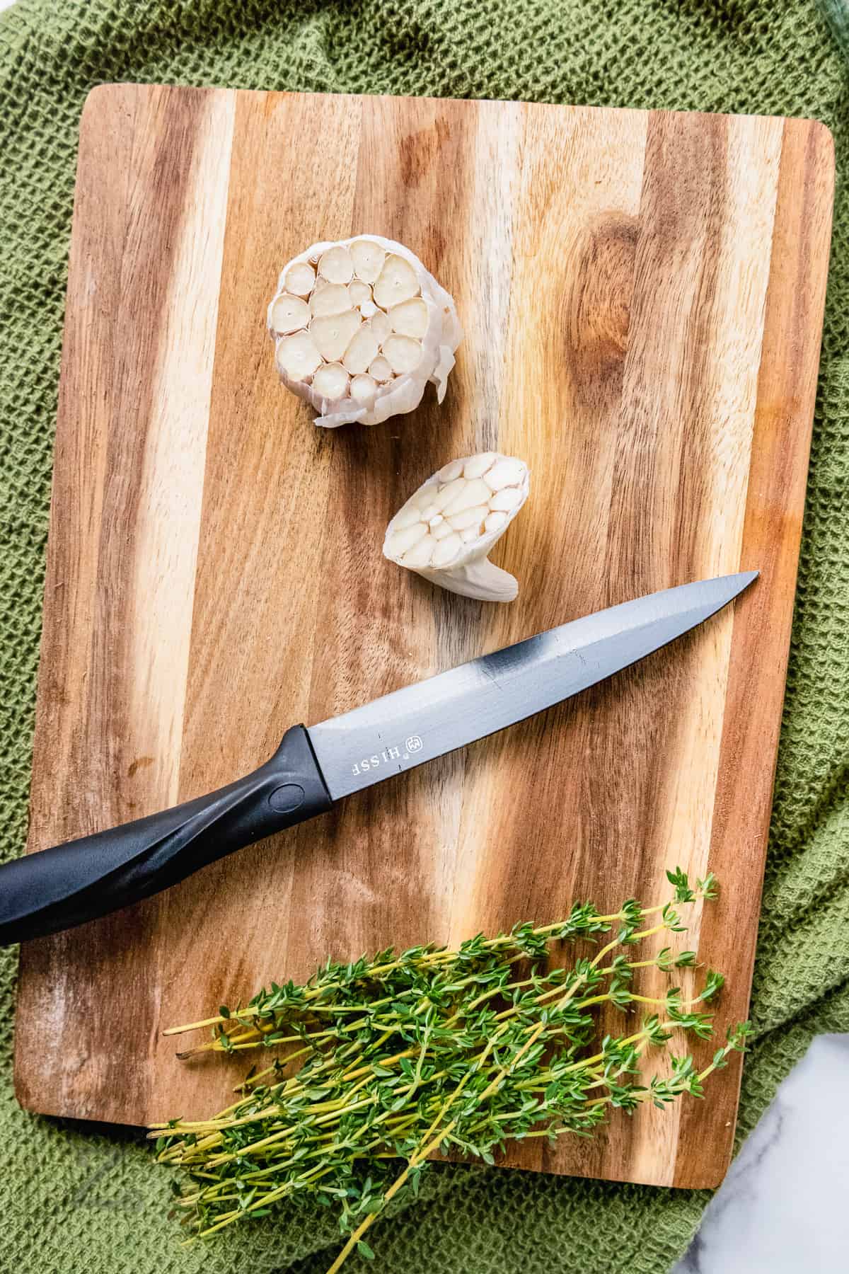 cutting open garlic to make Garlic Confit