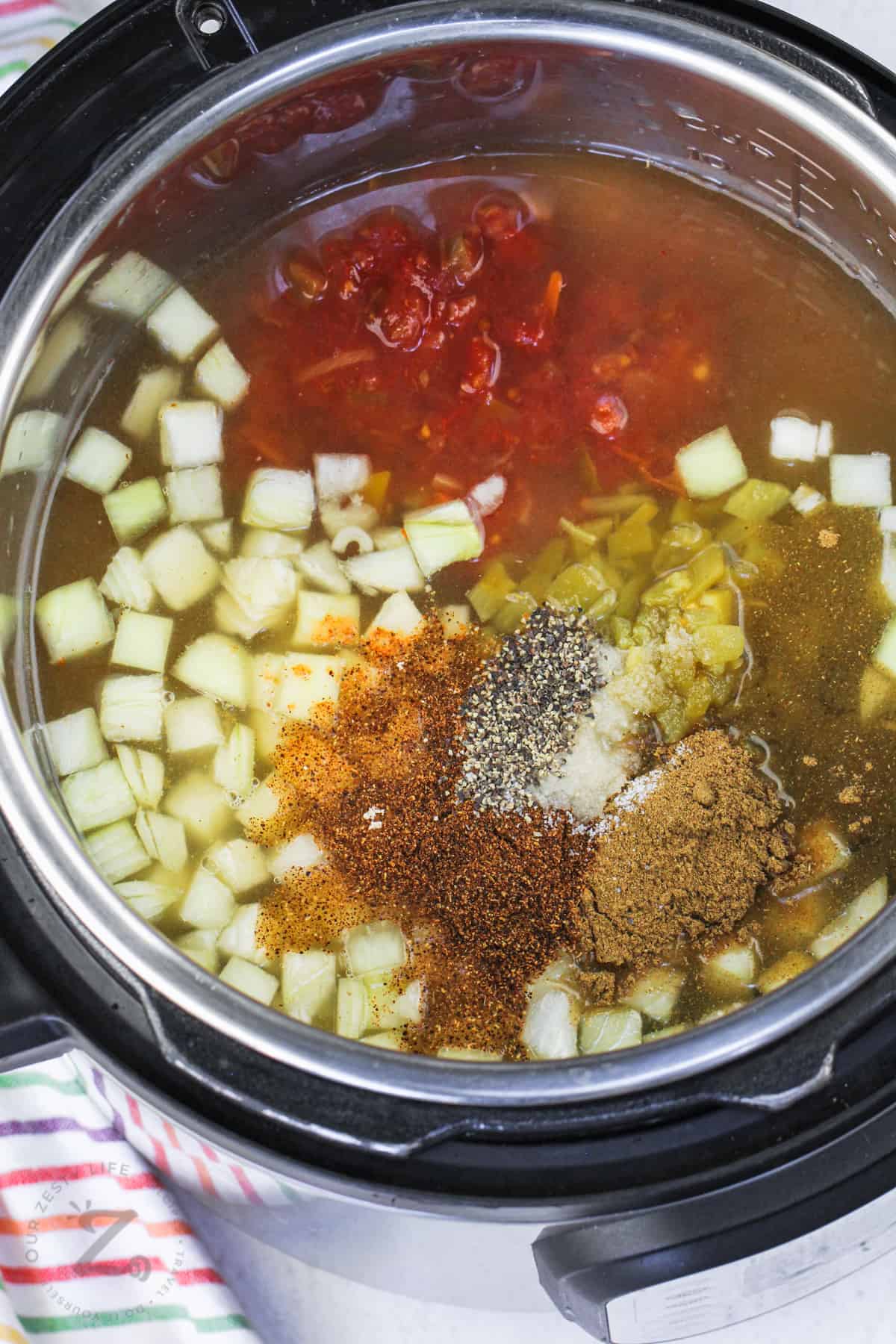 adding seasonings to pot to make Instant Pot Tortilla Chicken Soup