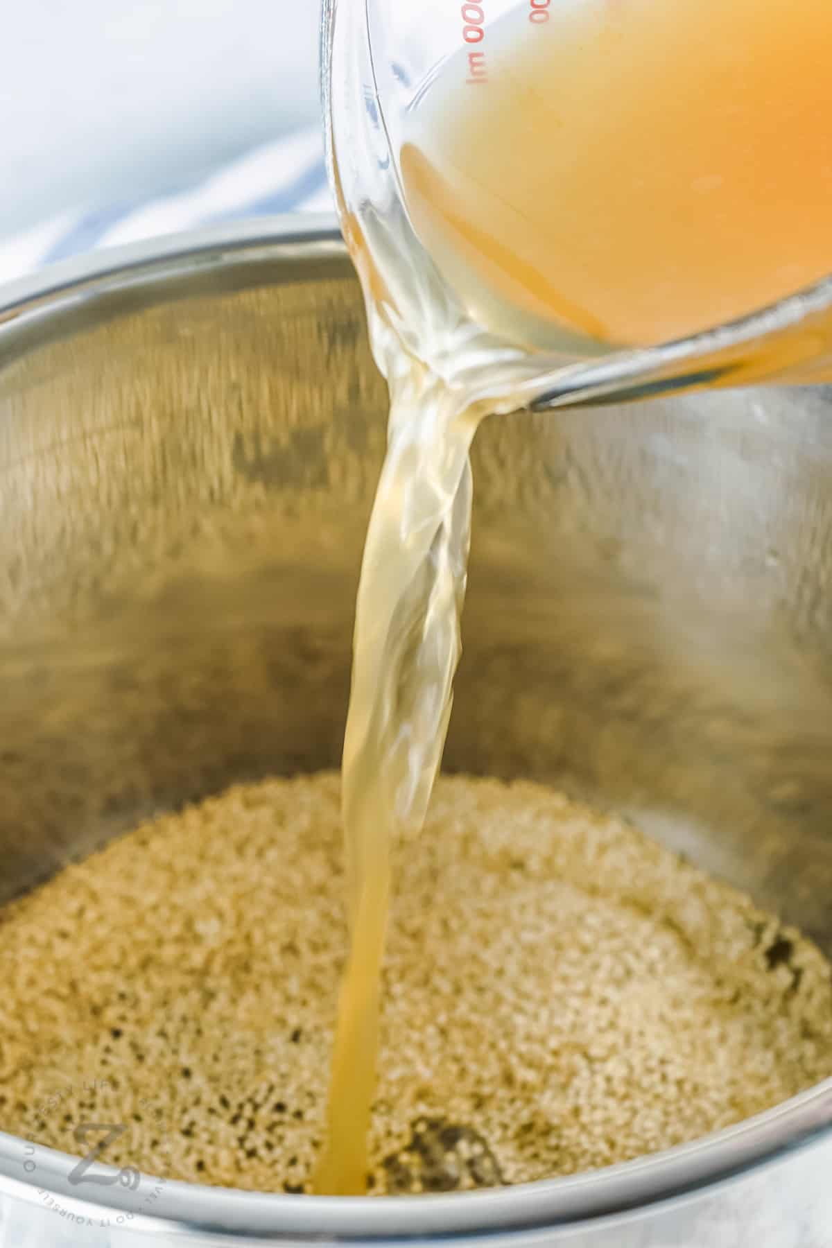 adding broth to quinoa to make Instant Pot Quinoa