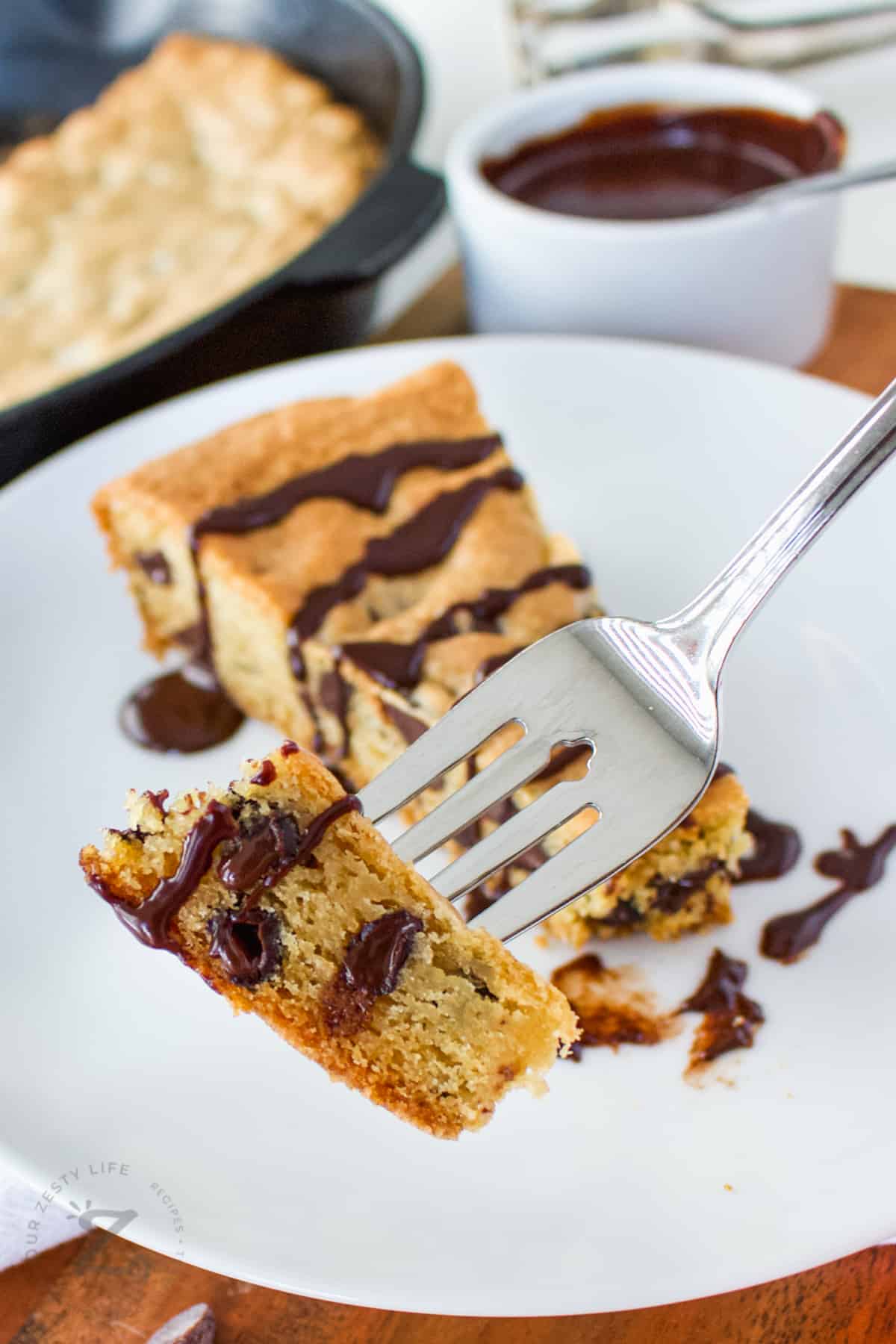 slice of Skillet Cookie Recipe on a plate with a fork full
