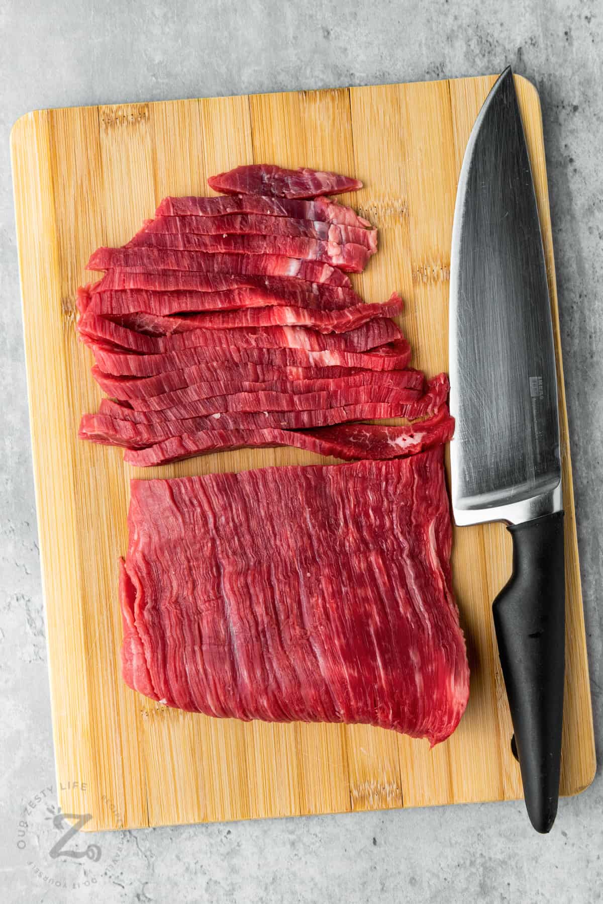 slicing beef to make Slow Cooker Mongolian Beef