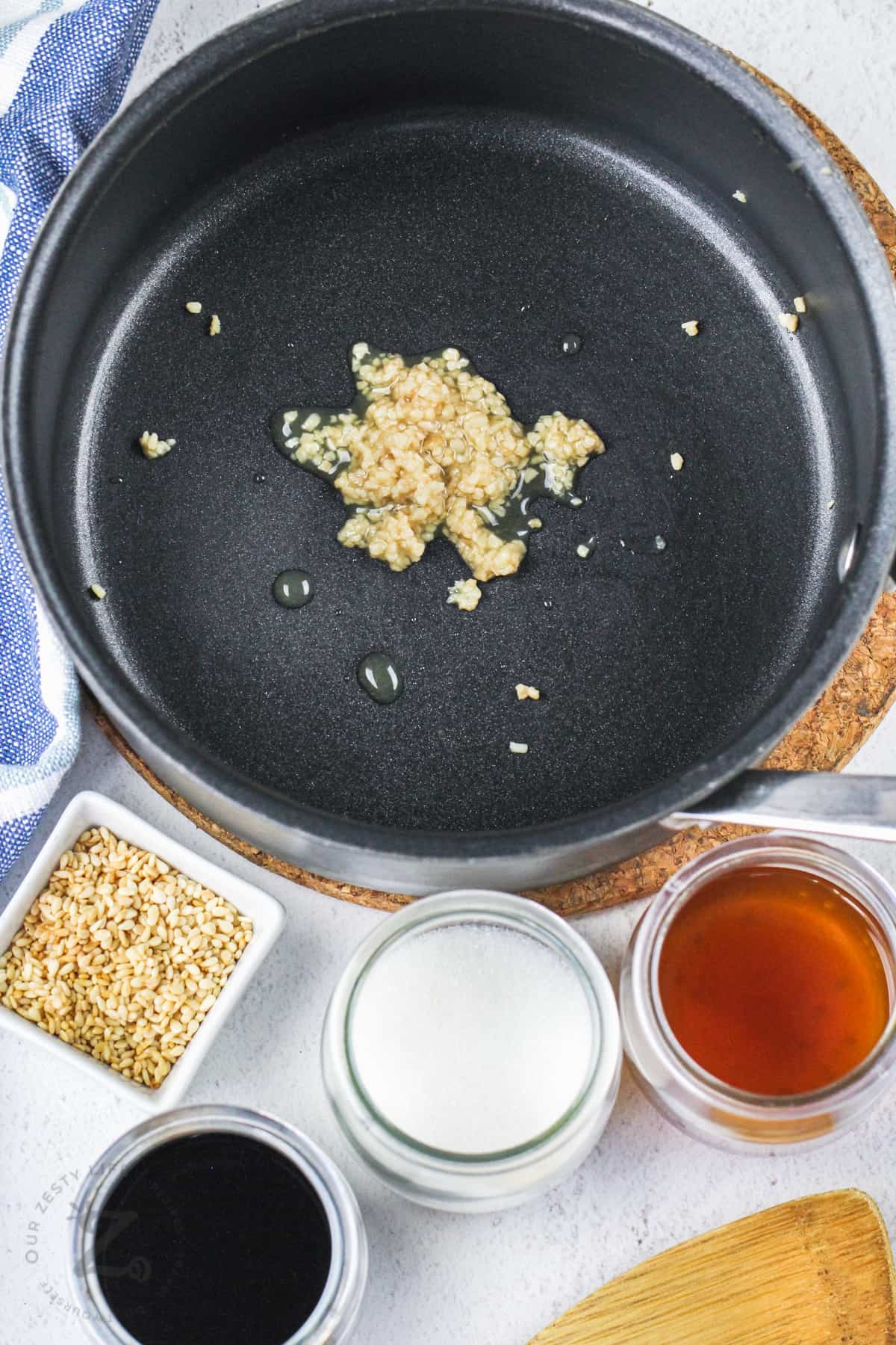 garlic in a pan with jars of ingredients to make Baked Teriyaki Chicken Wings