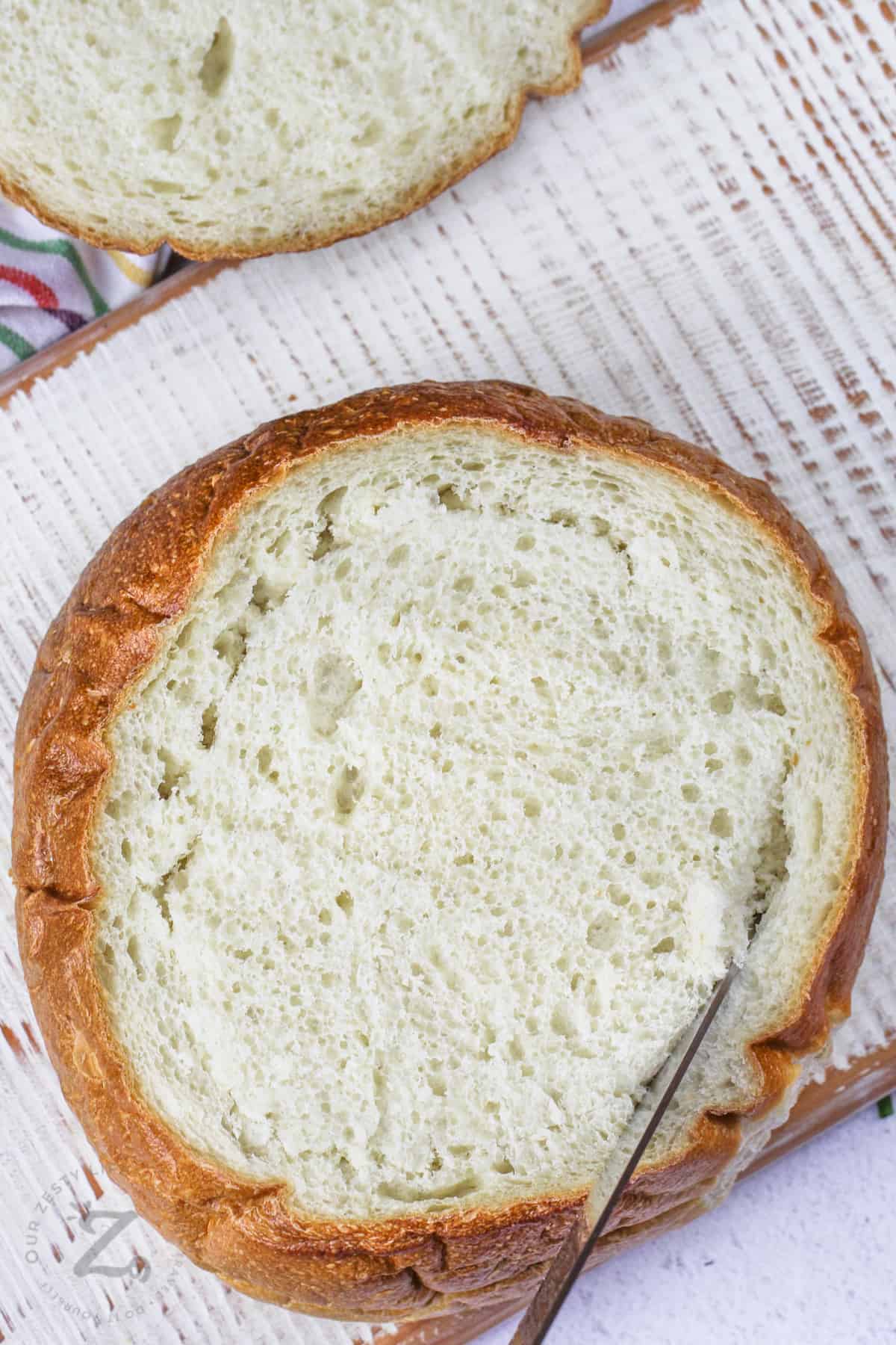 cutting a hole in bread to make a bread bowl for Spinach Dip