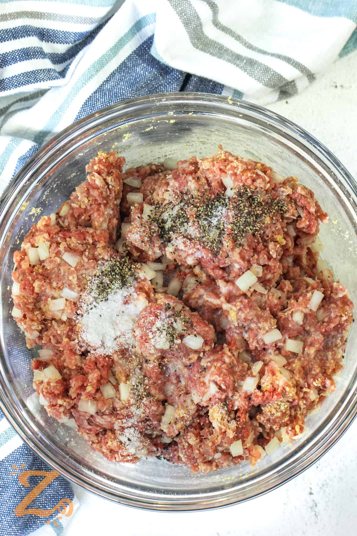 adding seasonings to meat to make Swedish Meatballs