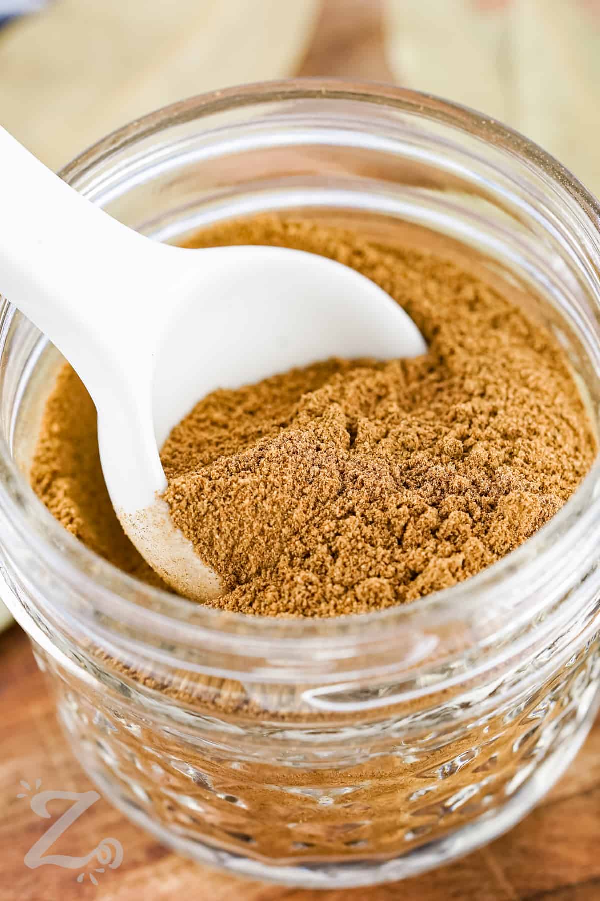 taking a scoop of Apple Pie Spice out of the jar