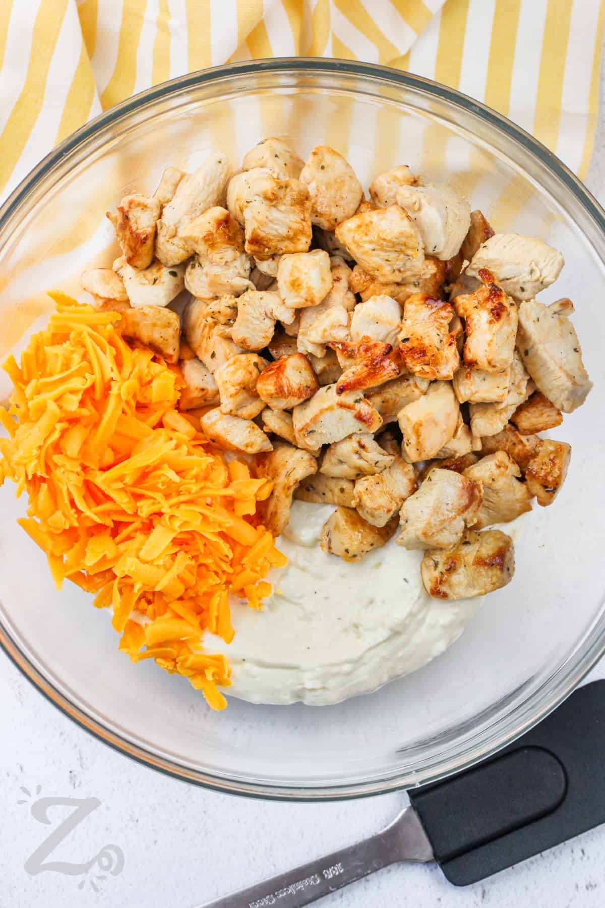 adding chicken and cheese to dressing to make Crack Chicken Casserole