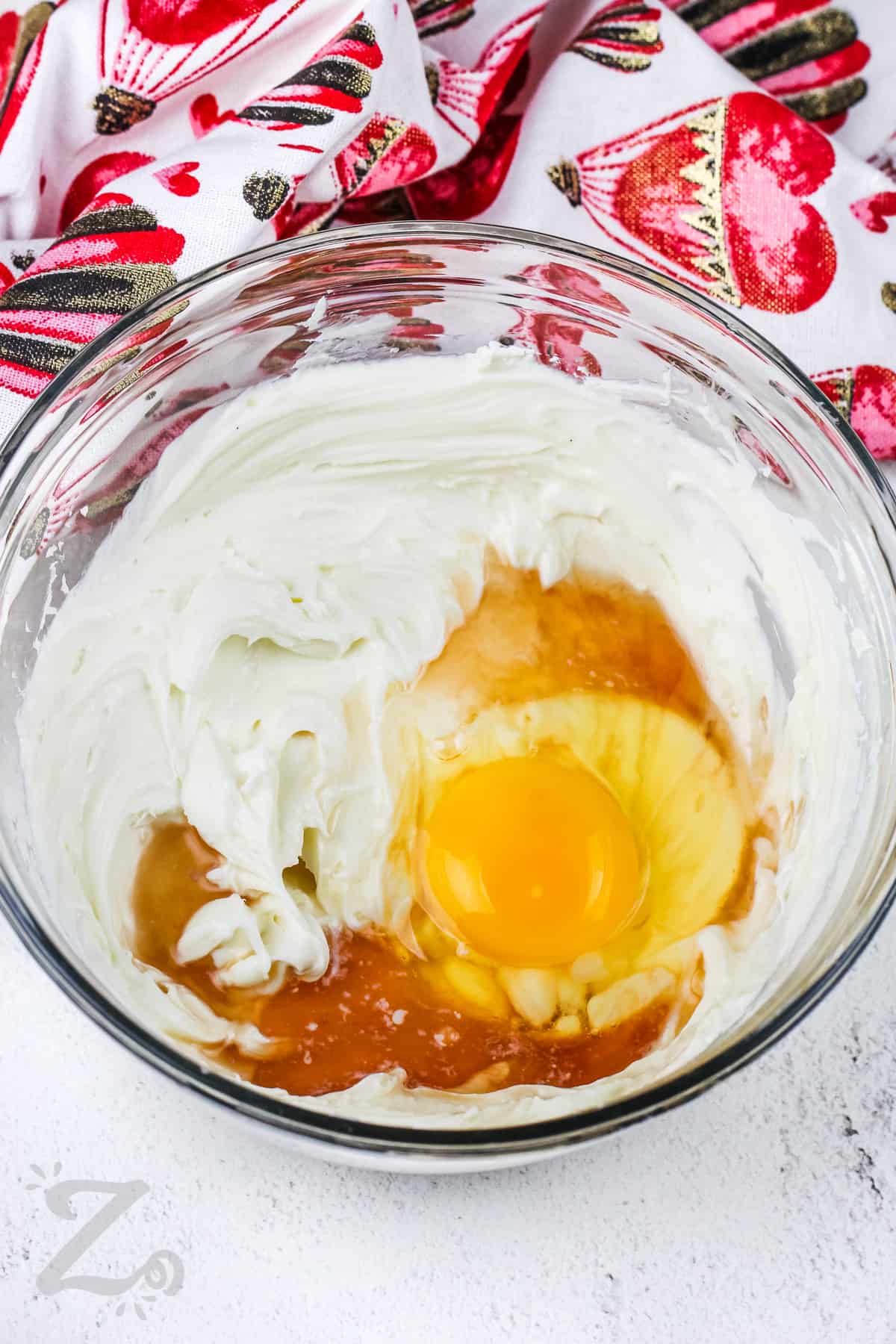 adding egg and vanilla to cream cheese mixture to make Cream Cheese Brownies