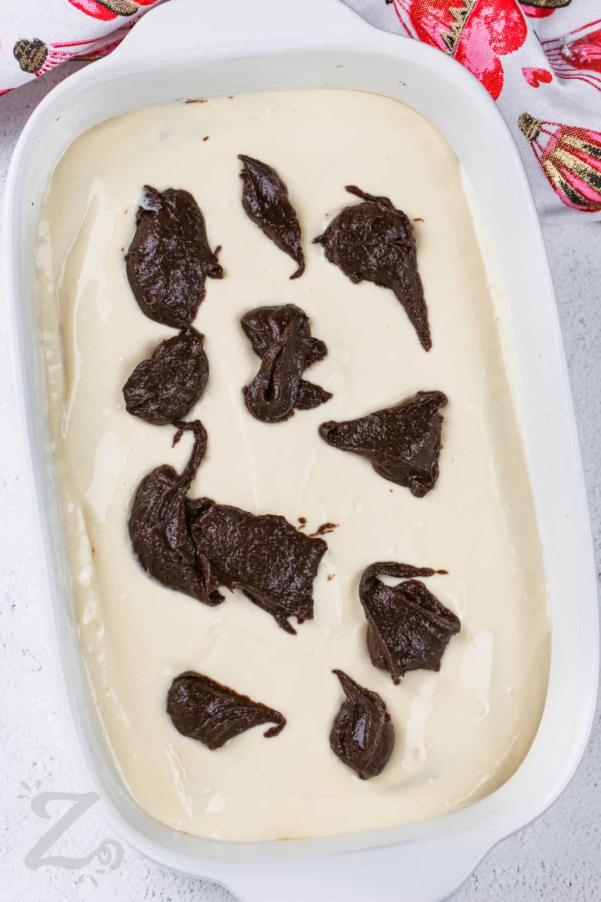 adding chocolate mixture on top of cream cheese mixture to make Cream Cheese Brownies