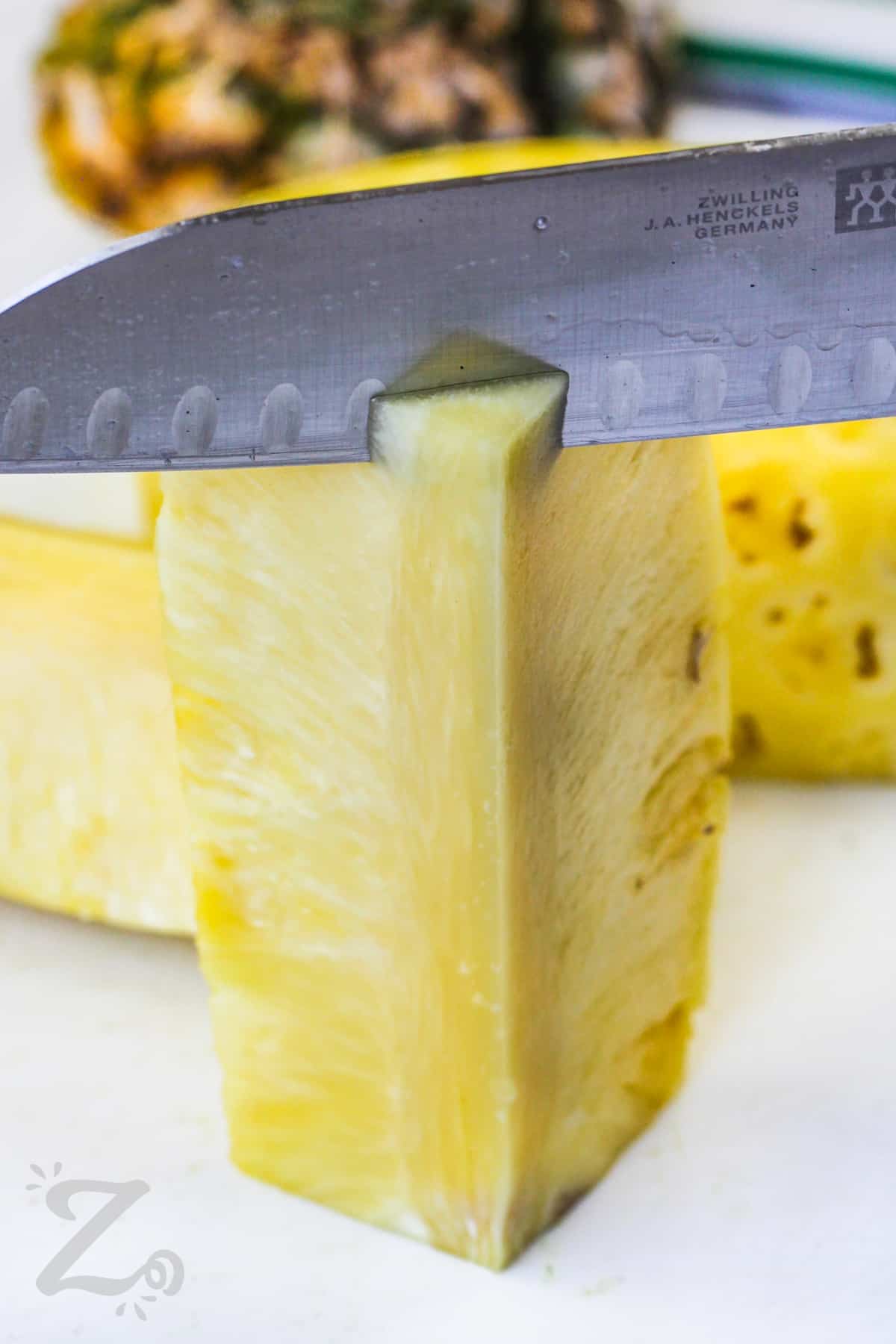 cutting off core of pineapple to make Grilled Pineapple