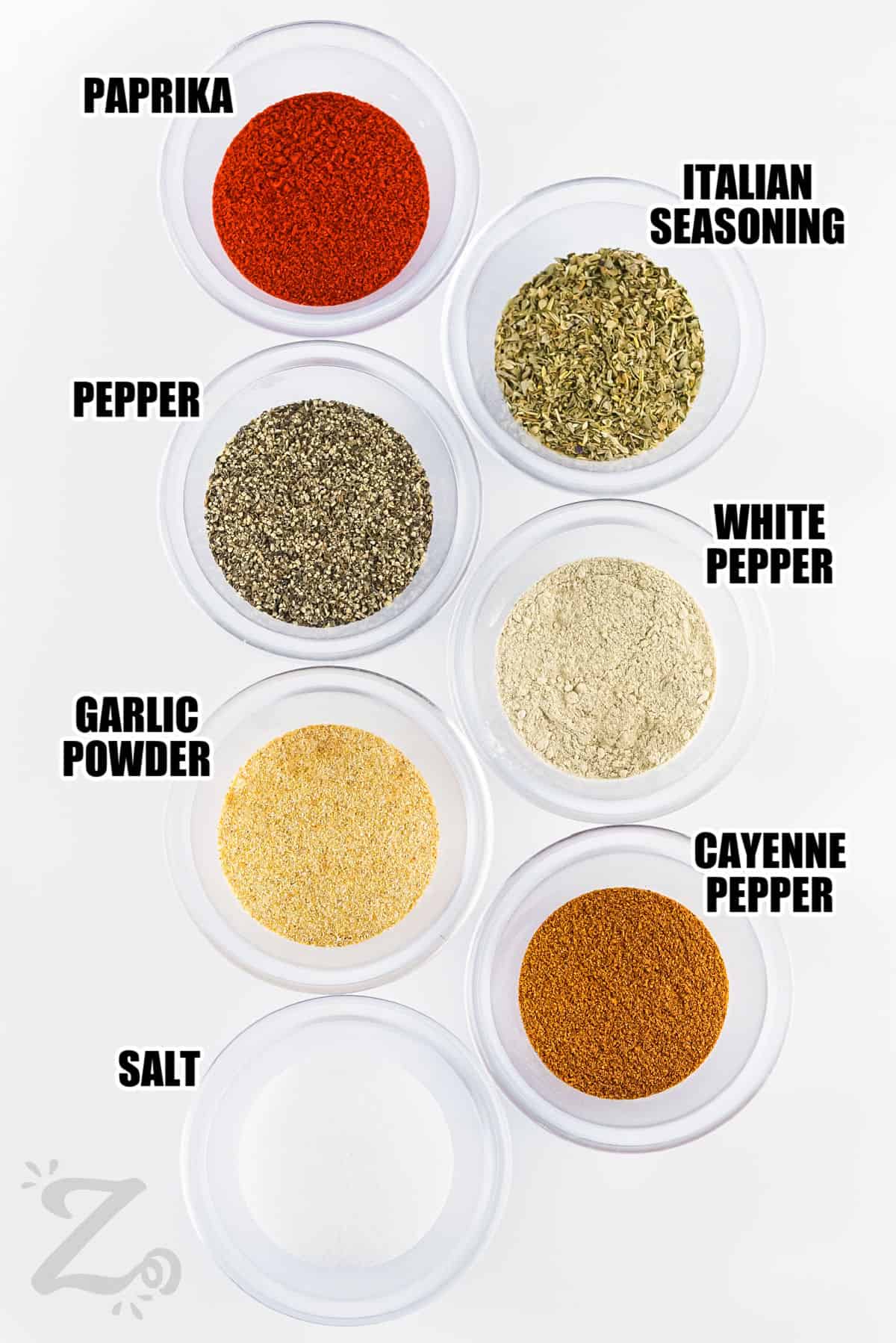 paprika , Italian seasoning , pepper , white pepper , garlic powder , cayenne pepper and salt with labels to make Cajun Seasoning