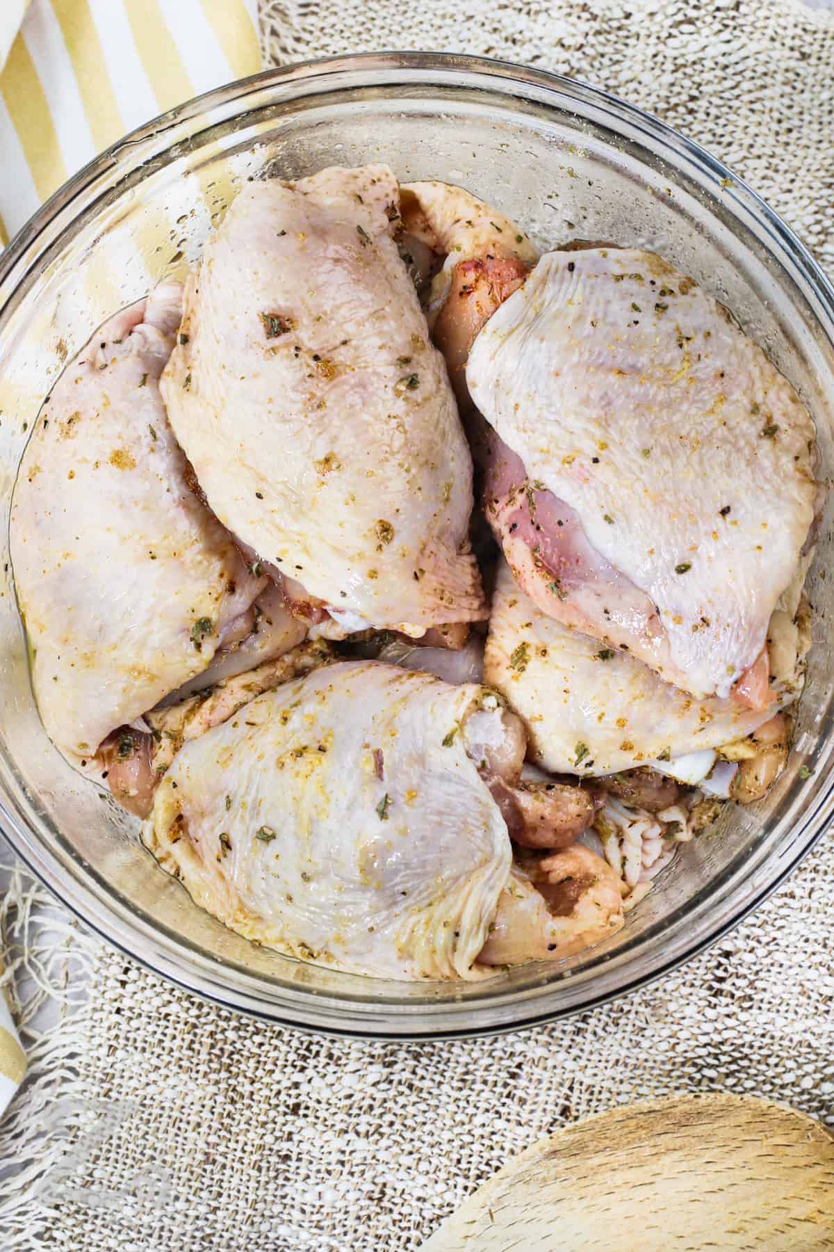 seasoned chicken in a bowl to make Baked Chicken Thighs
