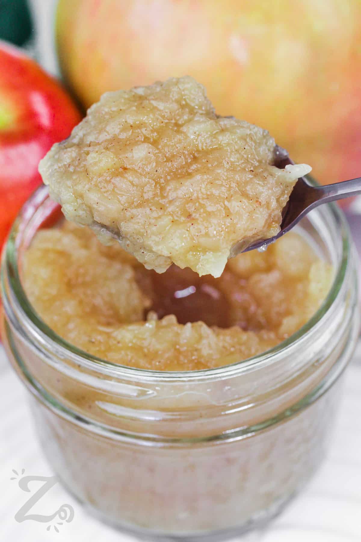 apple sauce being scooped out of a jar
