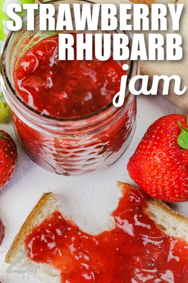 close up of Strawberry Rhubarb Jam on bread and in a jar with writing