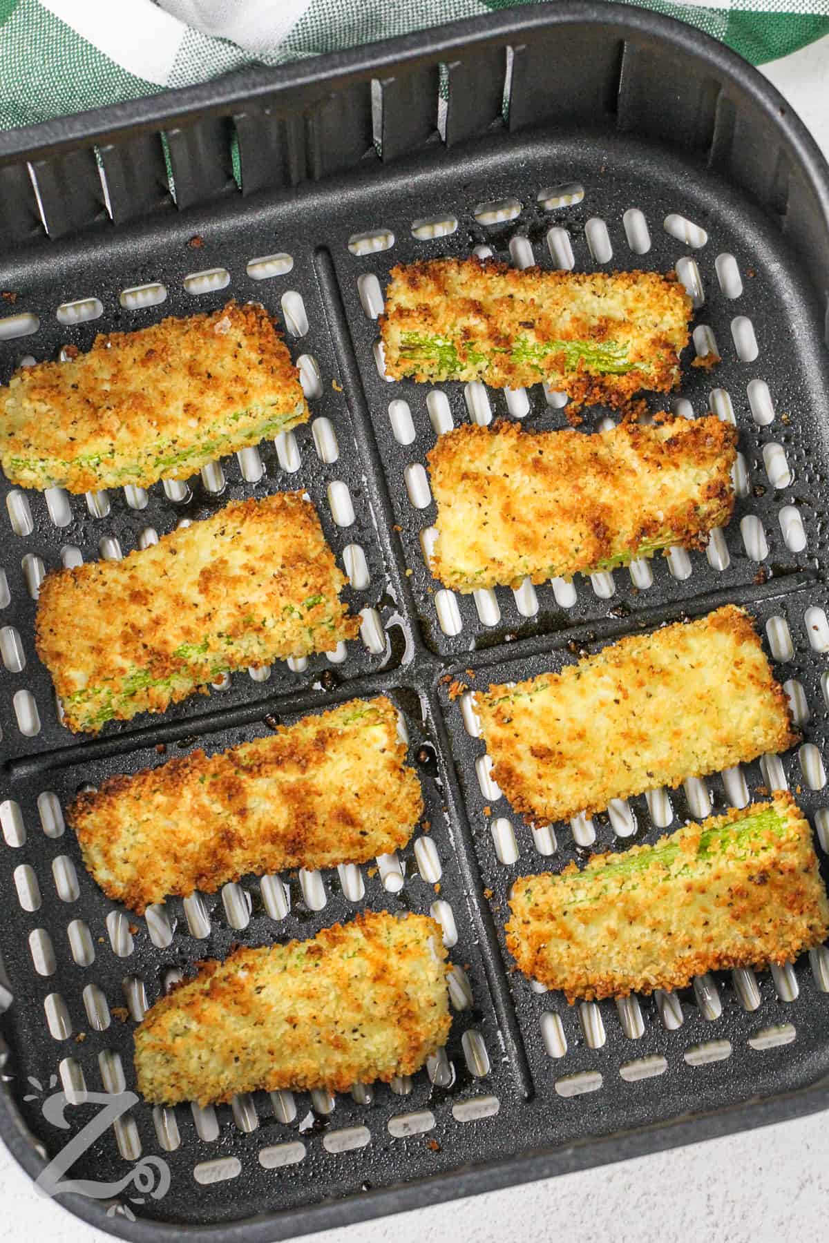 breaded zucchini sticks cooked in an air fryer basket