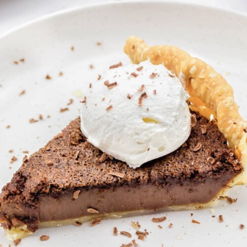 A slice of chocolate chess pie topped with whipped cream
