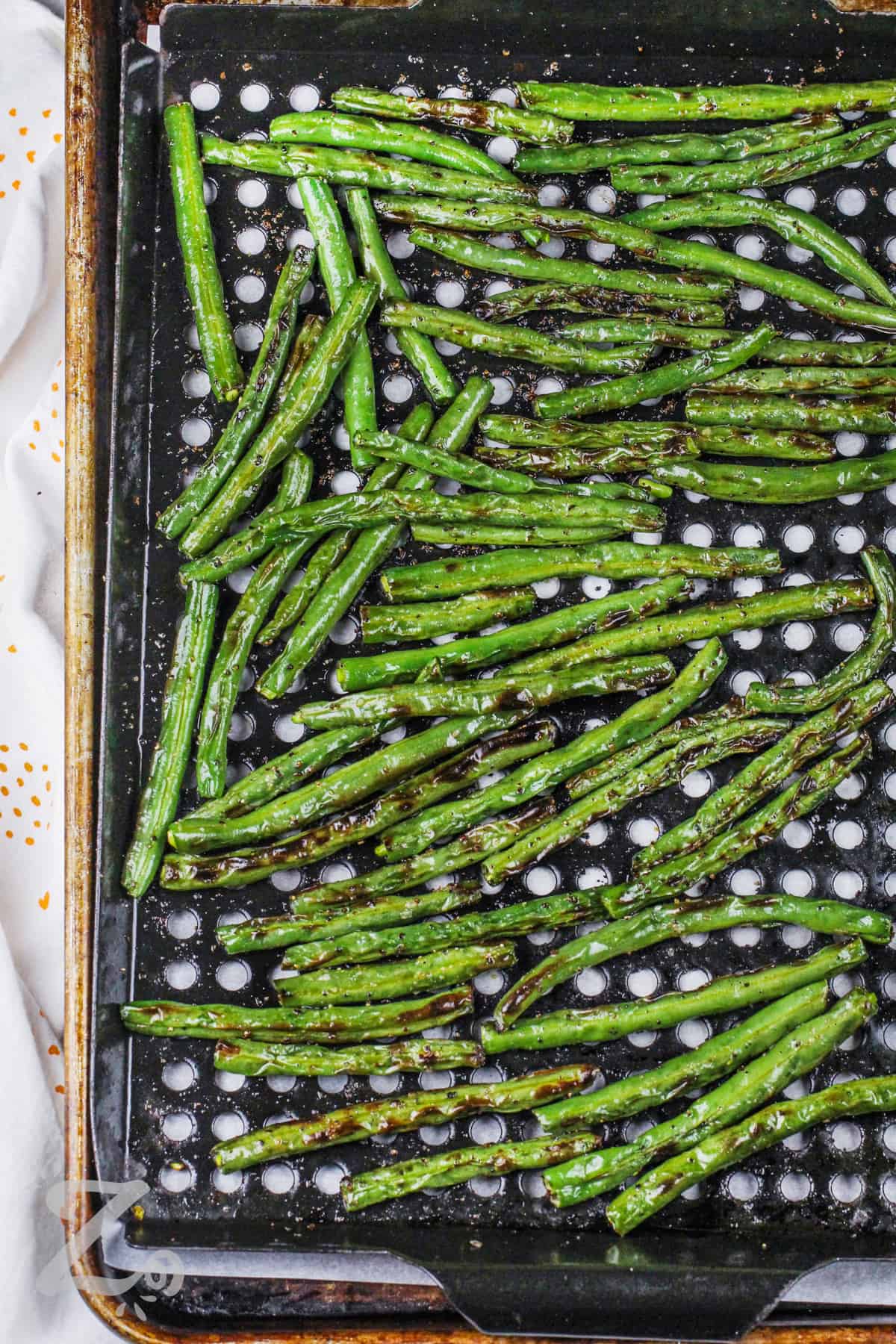 grilled green beans on a baking sheet