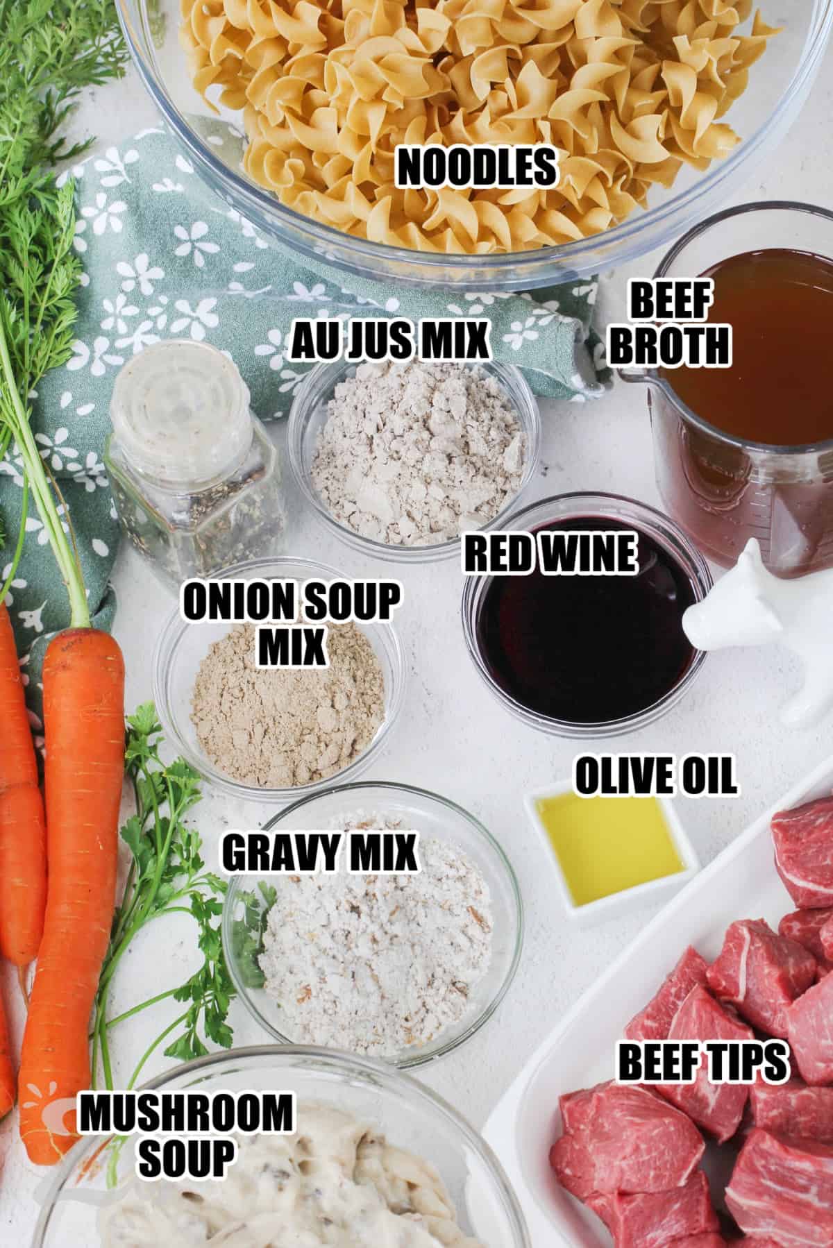 ingredients to make beef tips and gravy labeled: boodles, au jus mix, beef broth, onion soup mix, red wine, olive oil. gravy mix, beef tips, and mushroom soup.