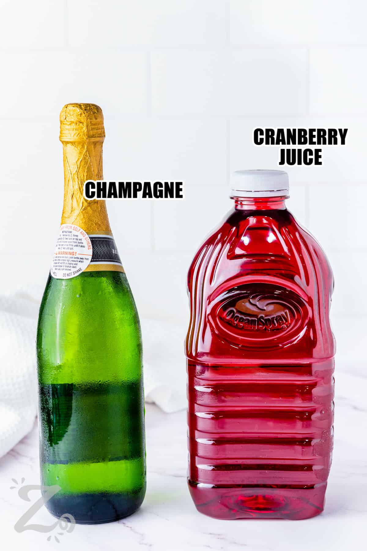 champagne and cranberry juice with labels to show how to make Cranberry Mimosas