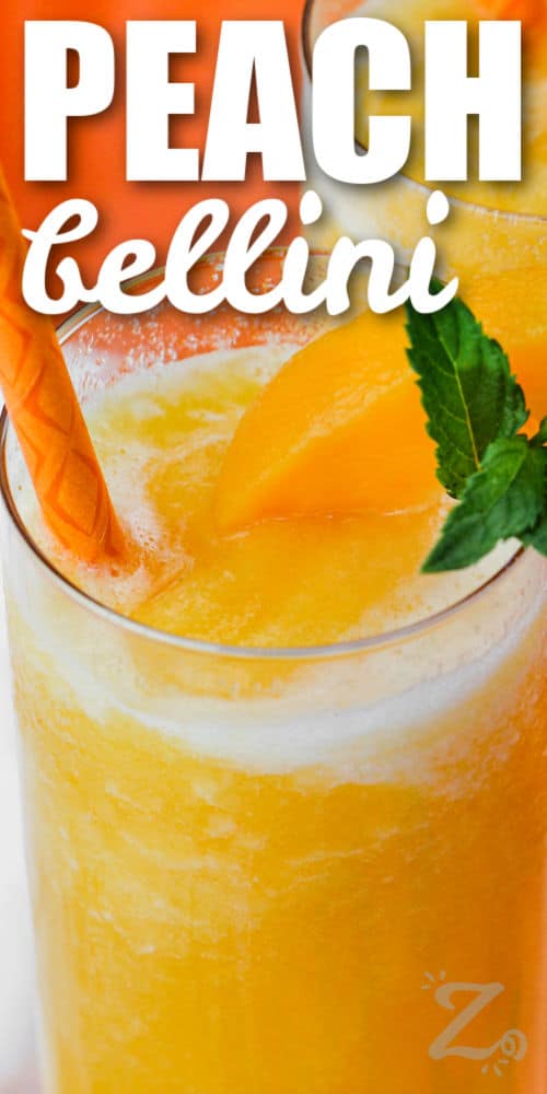 a glass of peach bellini with text