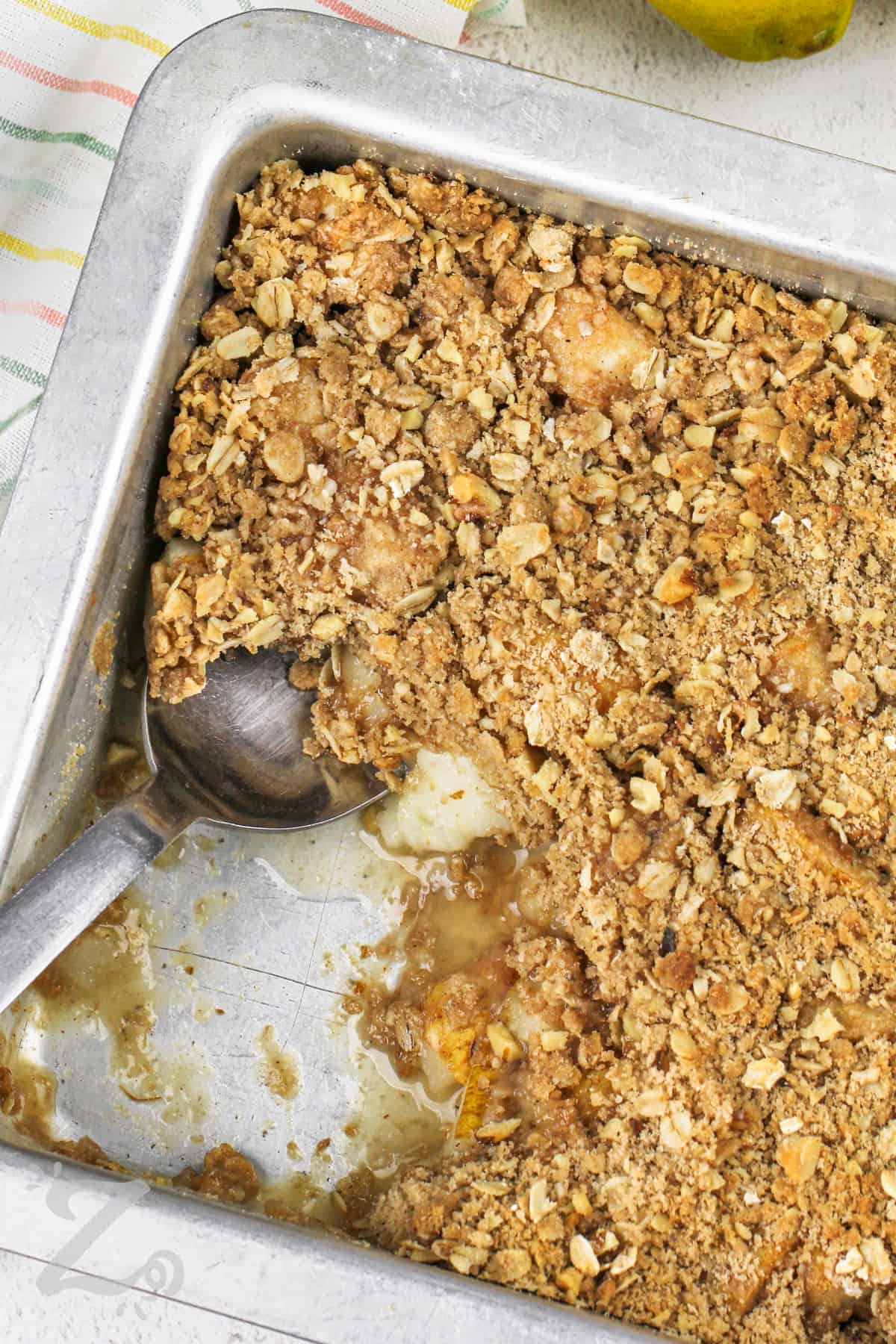 pear crisp being scooped out of a container