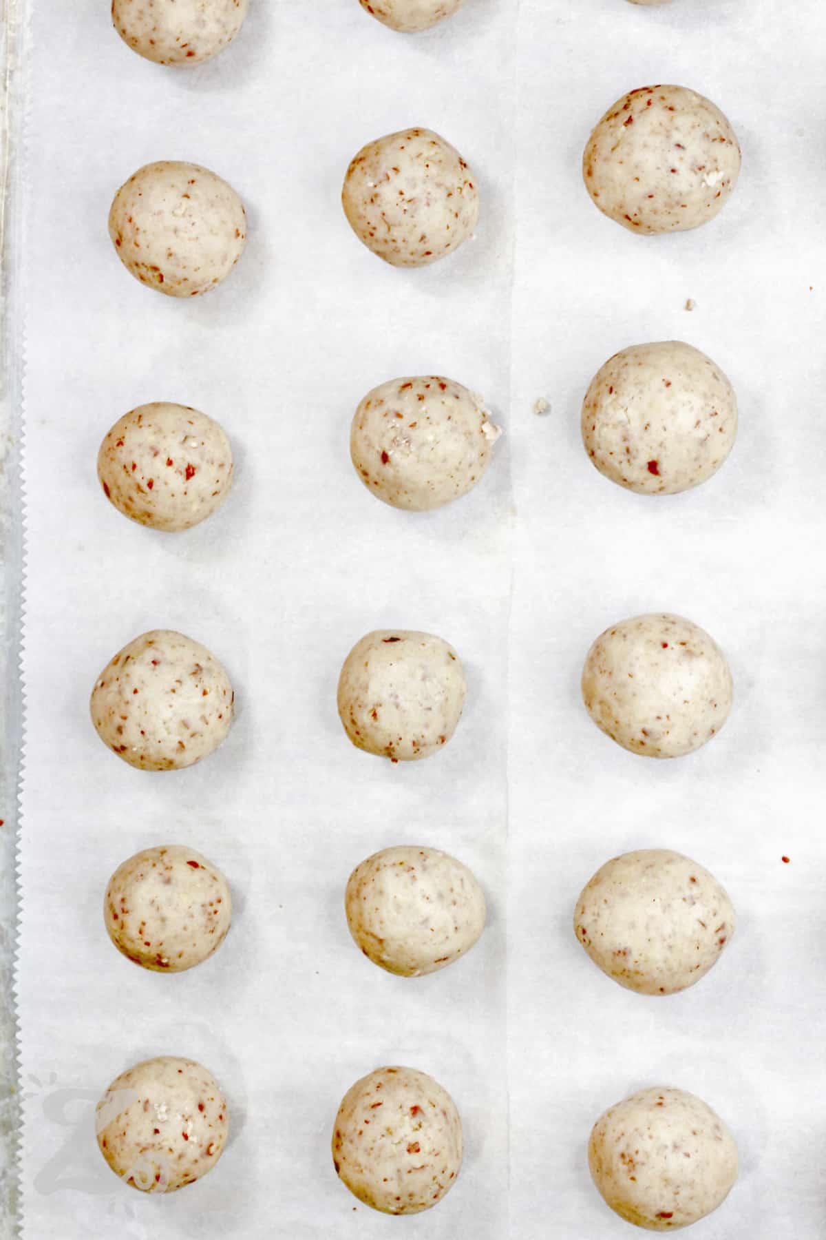 Pecan Snowball Cookies on a sheet pan before baking to make Pecan Snowball Cookies