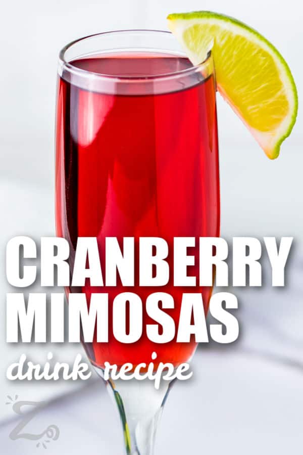Cranberry Mimosa with a lime wedge and writing