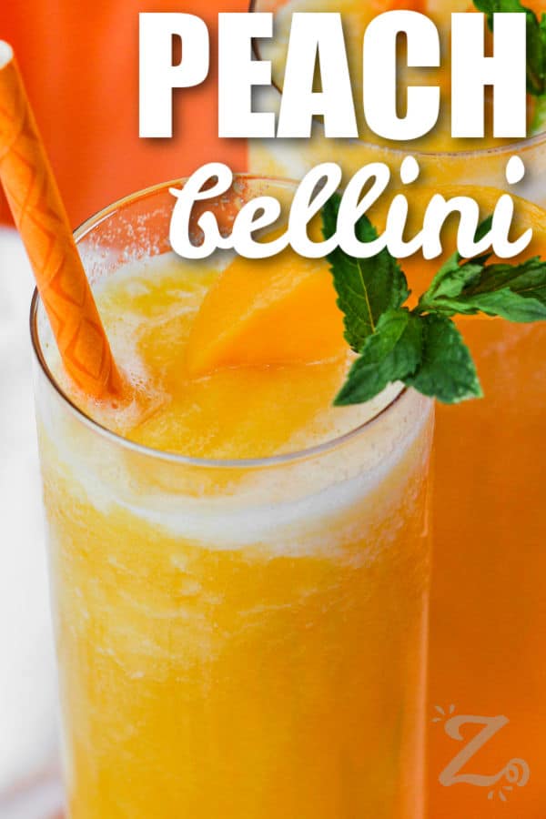 a glass of peach bellini topped with peach slices and mint leaves with text