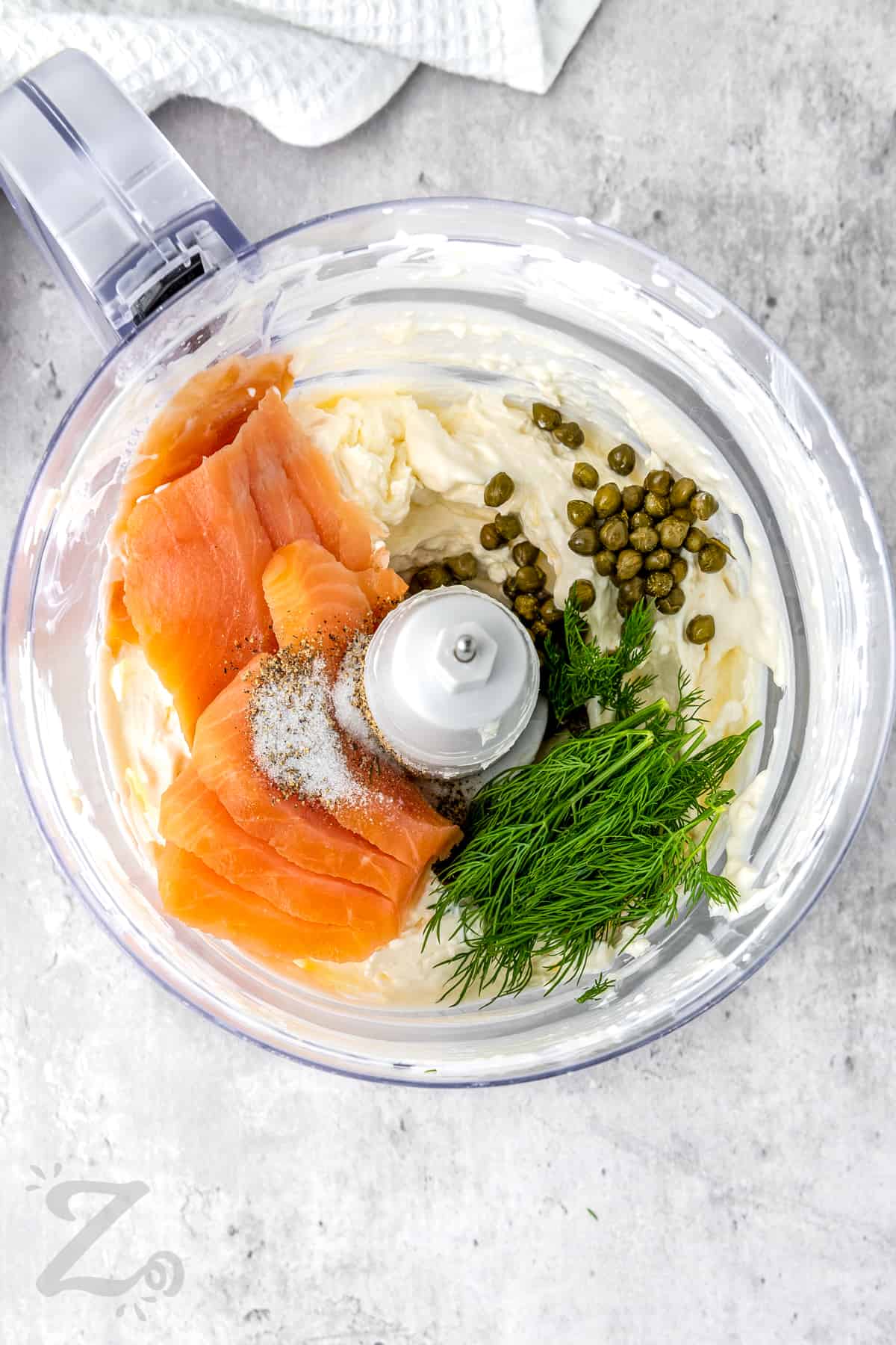 adding salmon , capers , dill and seasonings to food processor to make Smoked Salmon Dip