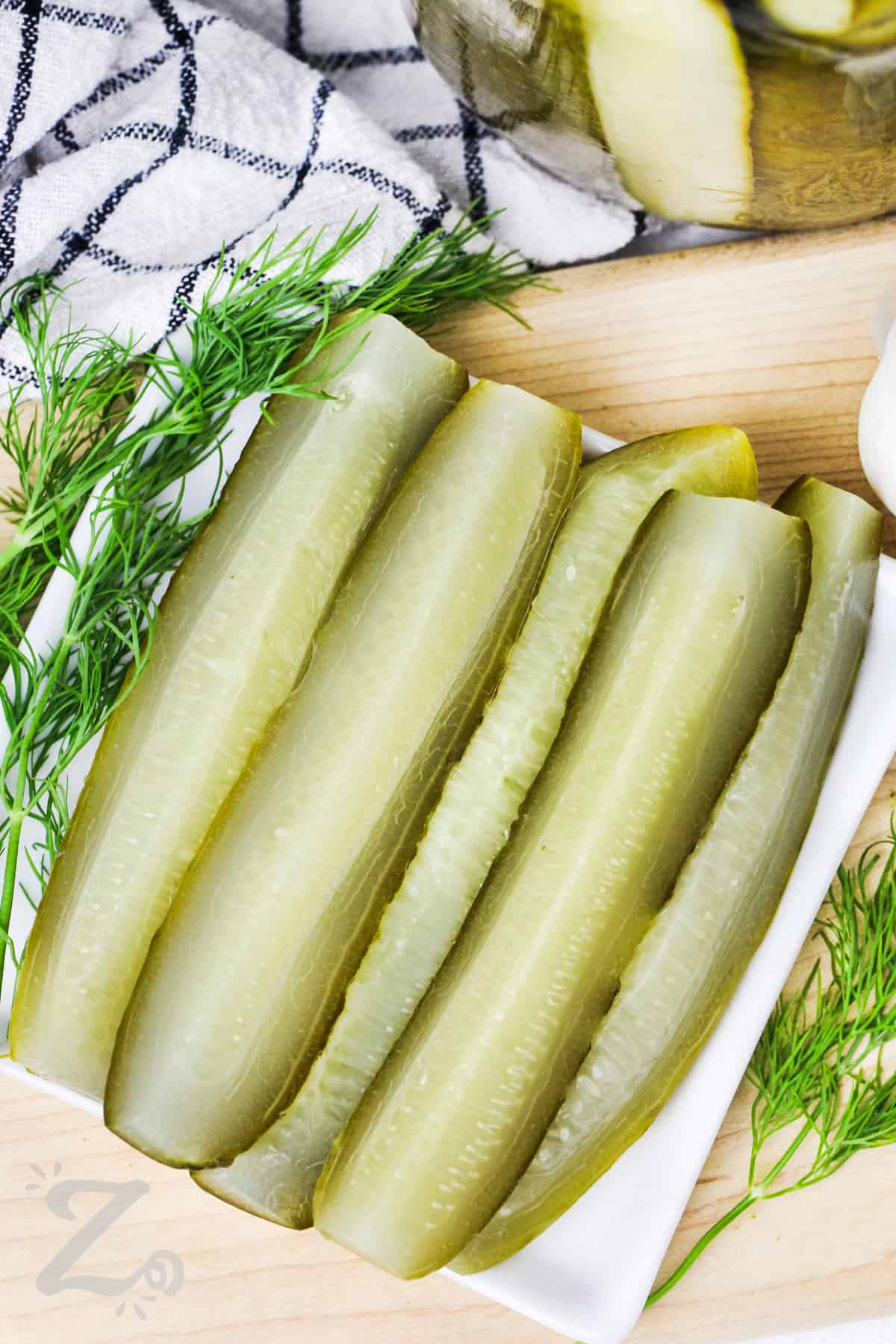 sliced dill pickles on a serving plate.